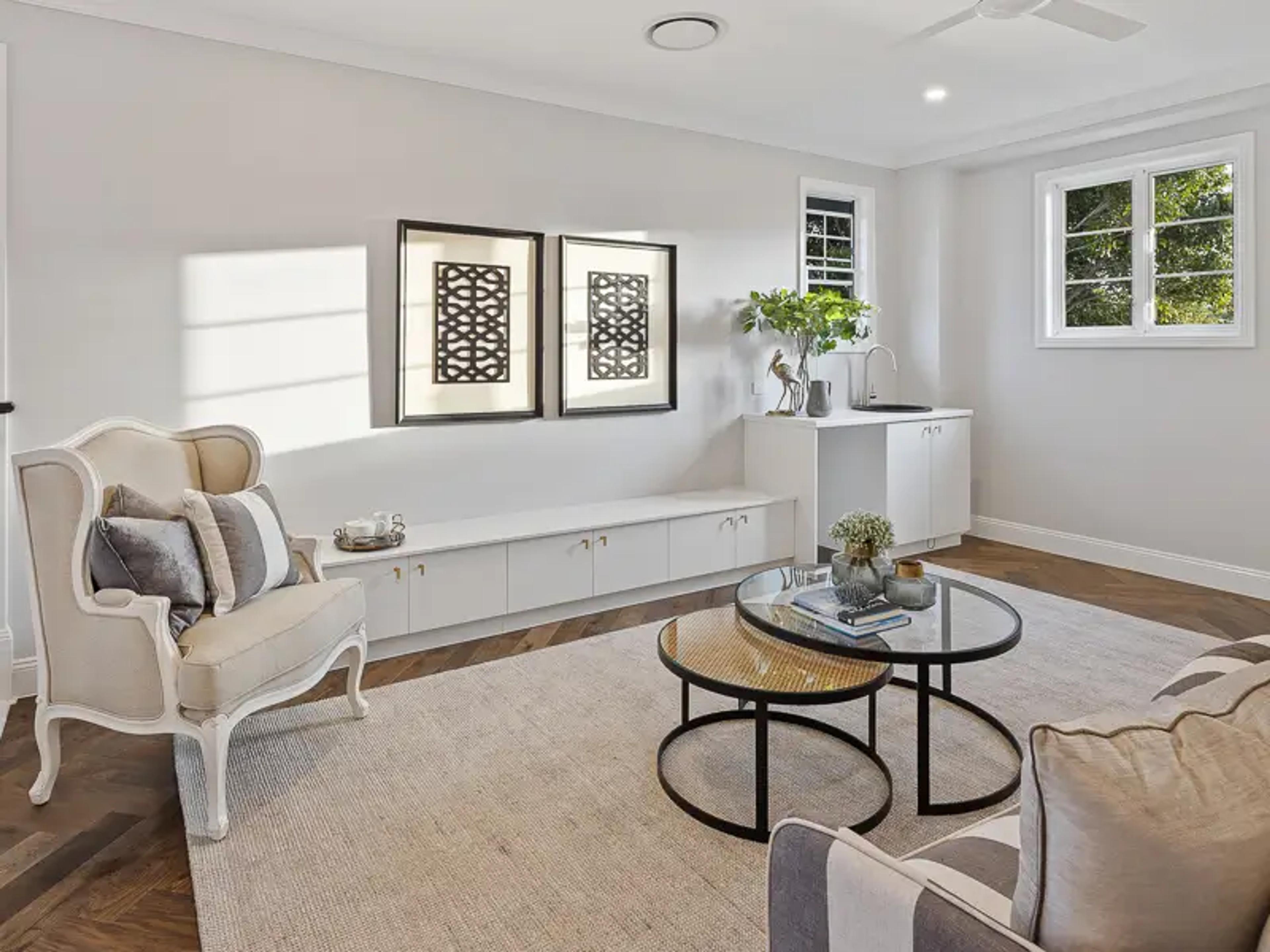 Sitting room with armchairs, built in bench and framed artwork