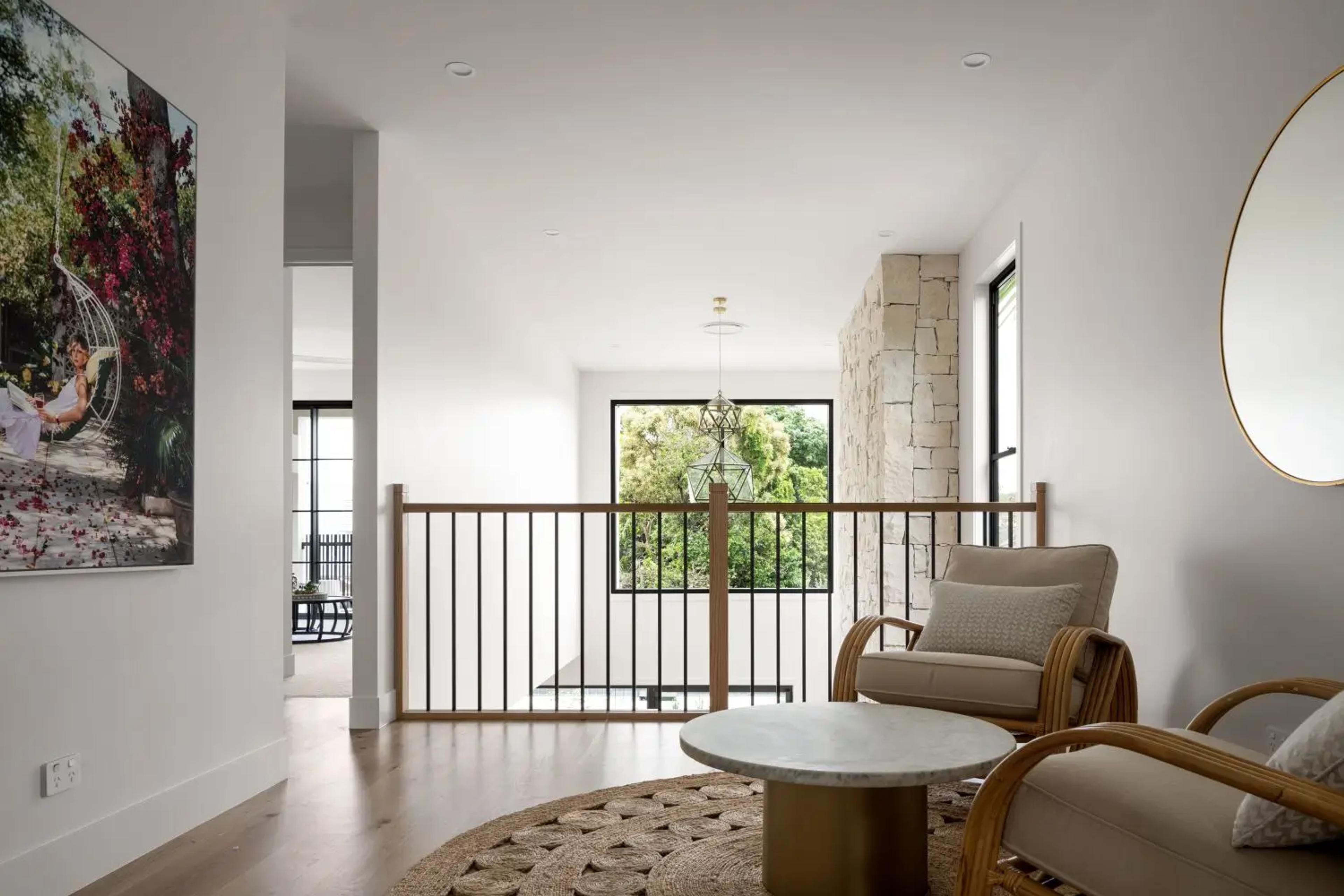 Upstairs landing with balustrade, armchairs and round table