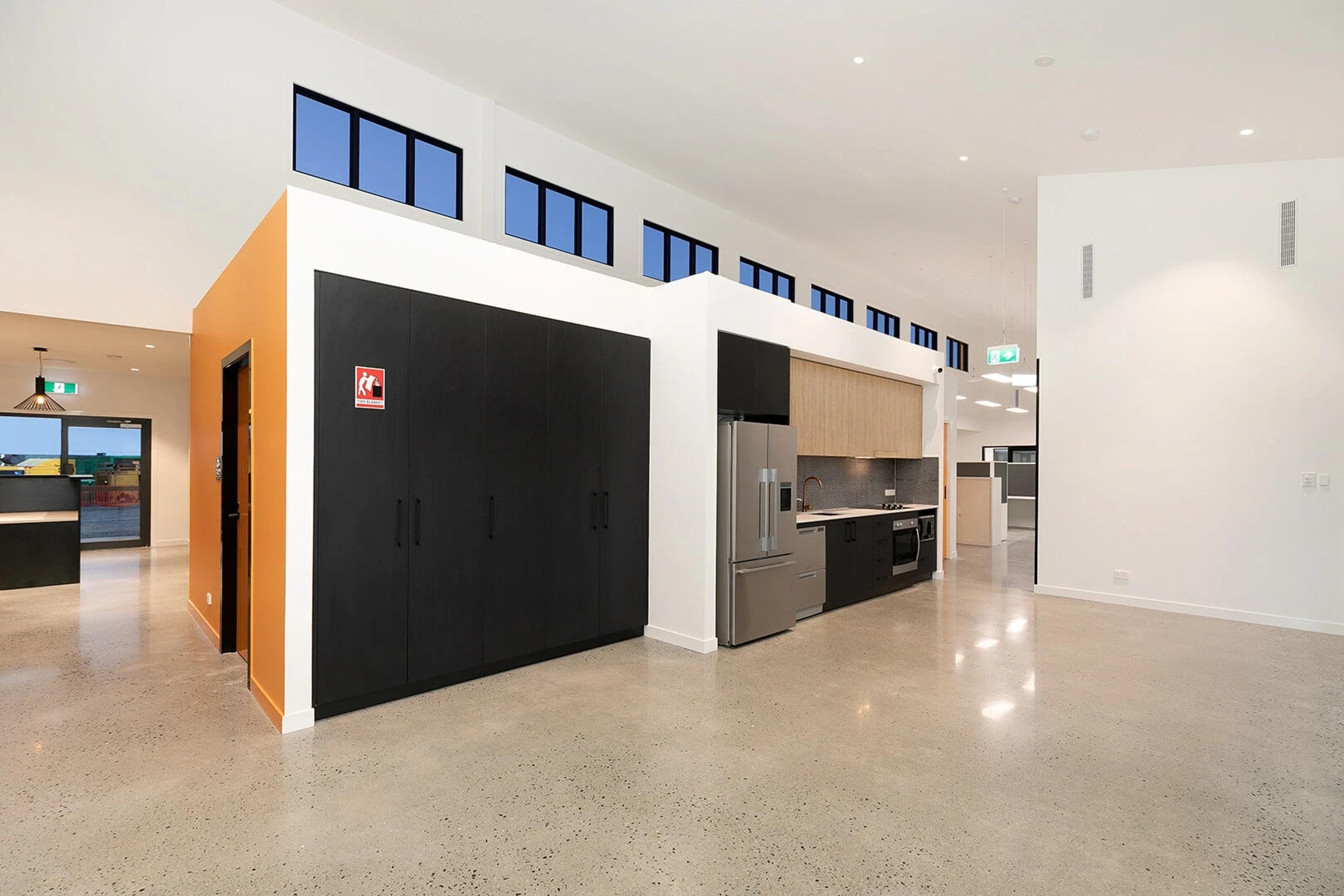 Open kitchen and storage cupboards in office breakout area
