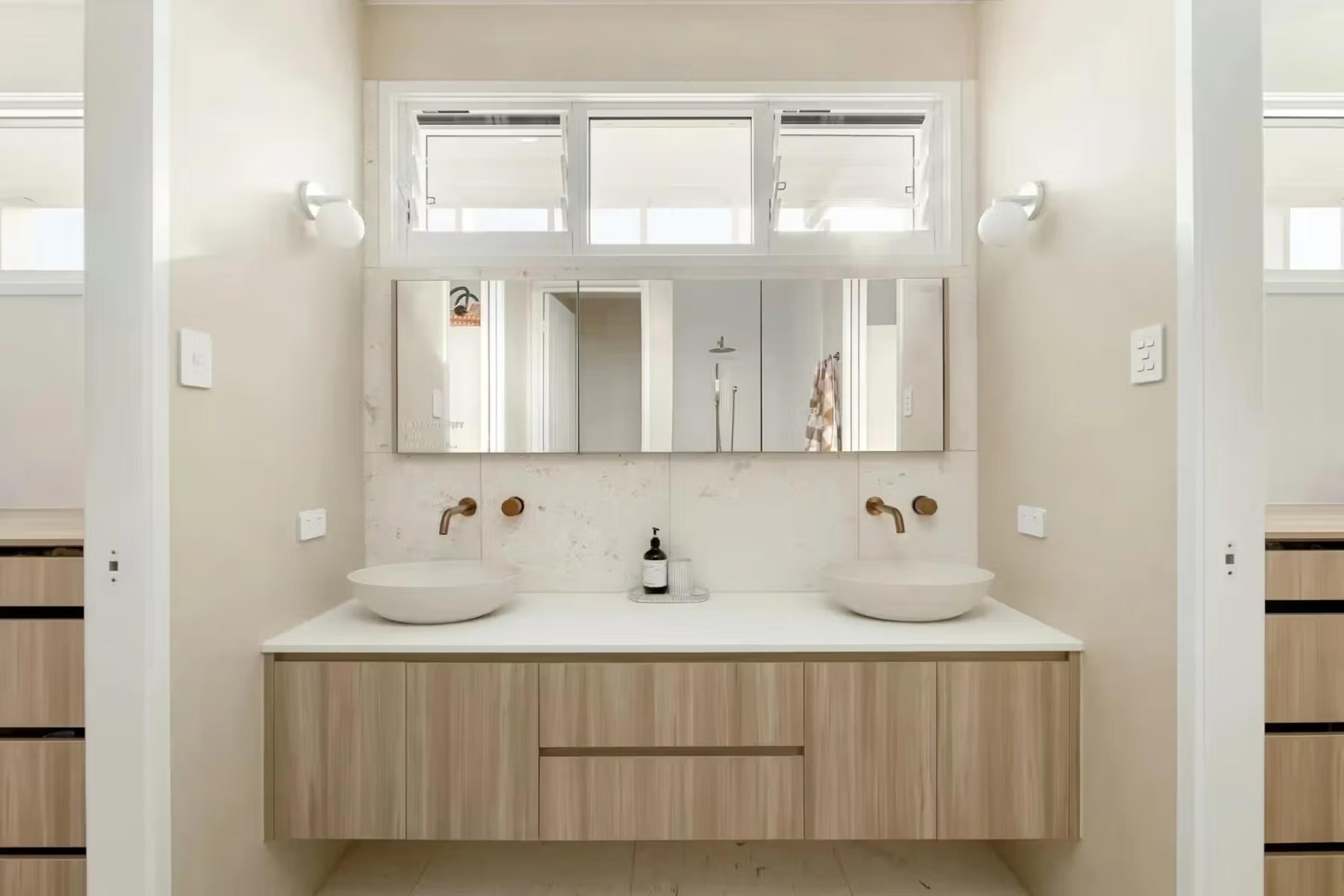 Master ensuite in a Brisbane home with double vanity, stone benchtop and high-set window above the joinery, designed by Invilla Architecture