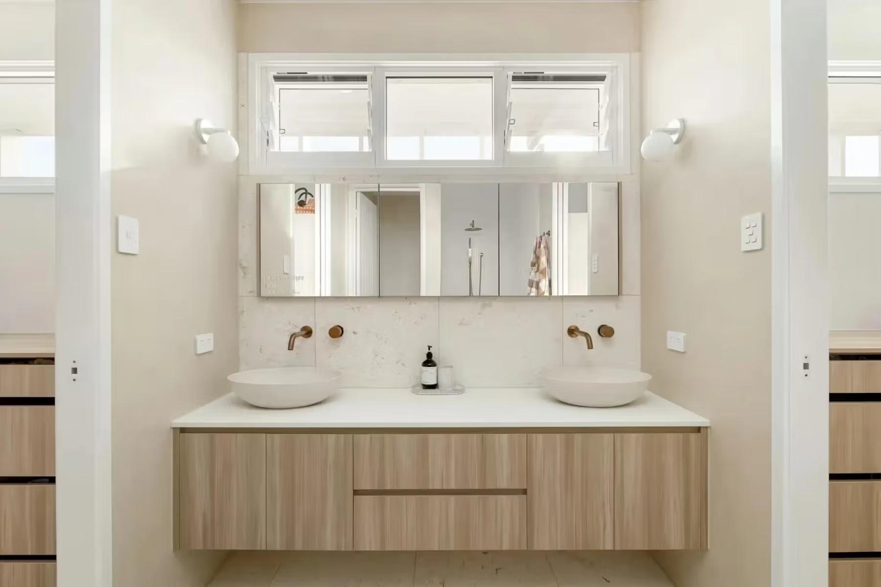 Master ensuite in a Brisbane home with double vanity, stone benchtop and high-set window above the joinery, designed by Invilla Architecture
