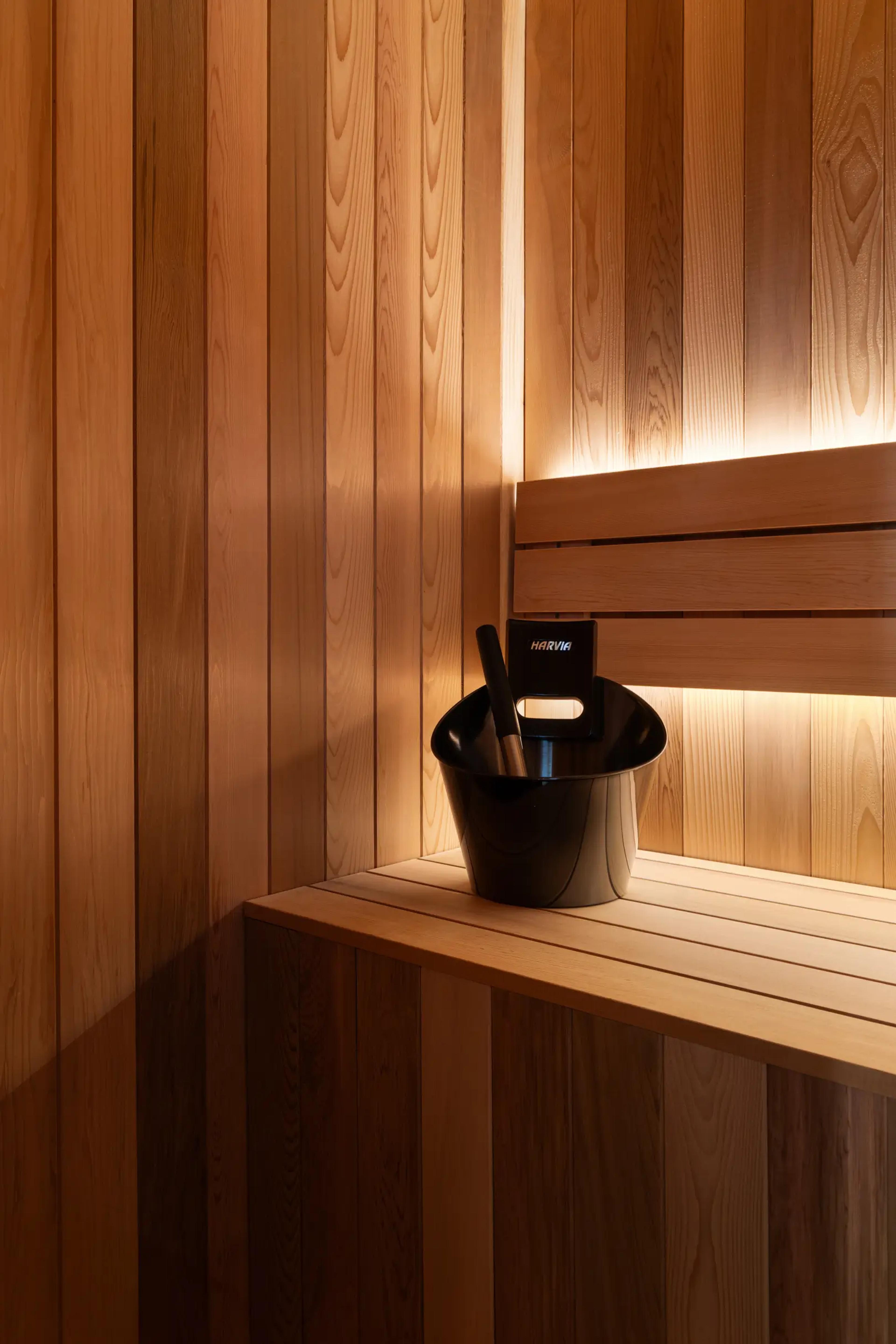 Cedar-lined sauna with bench and water bucket