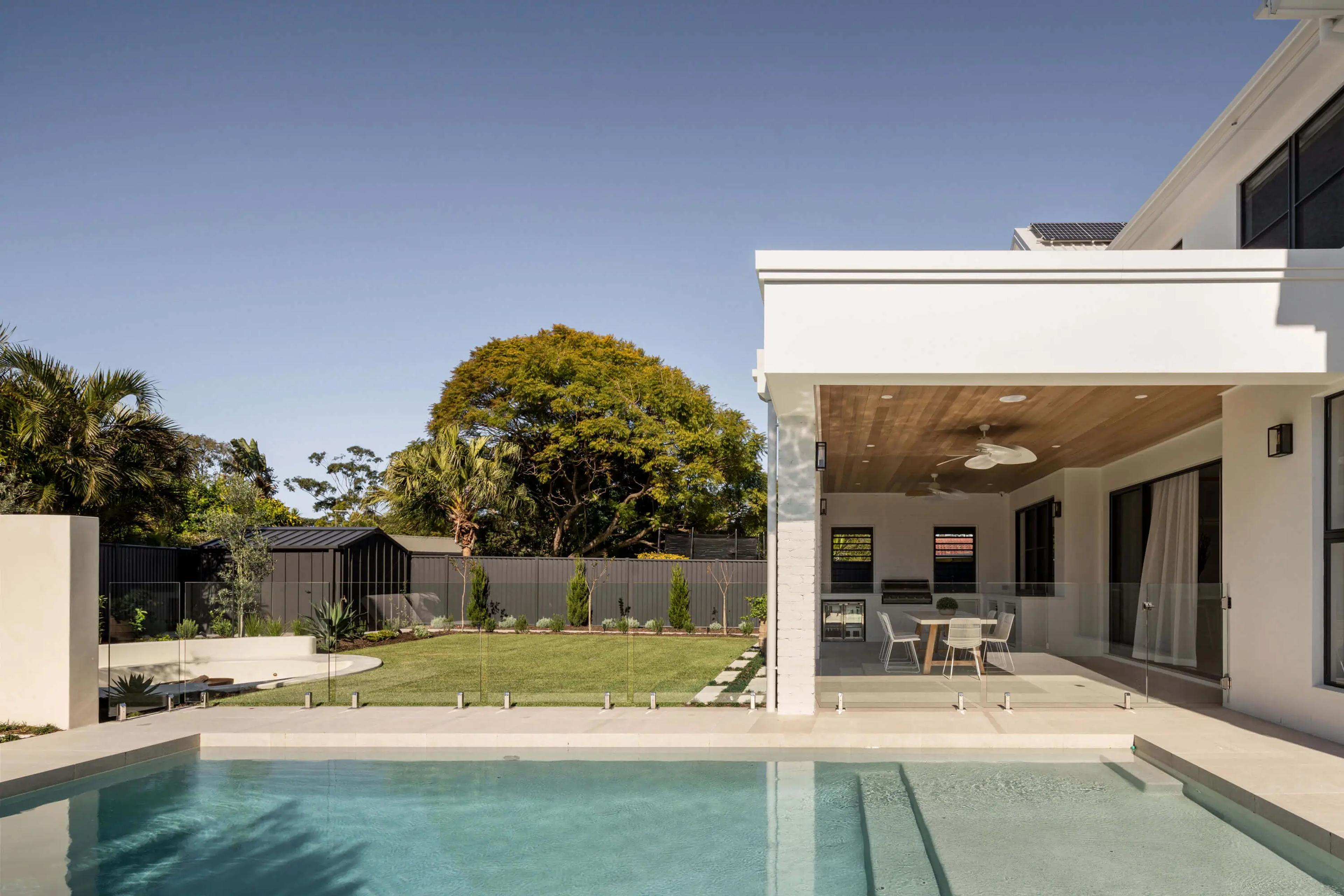 Poolside view toward covered outdoor living and garden