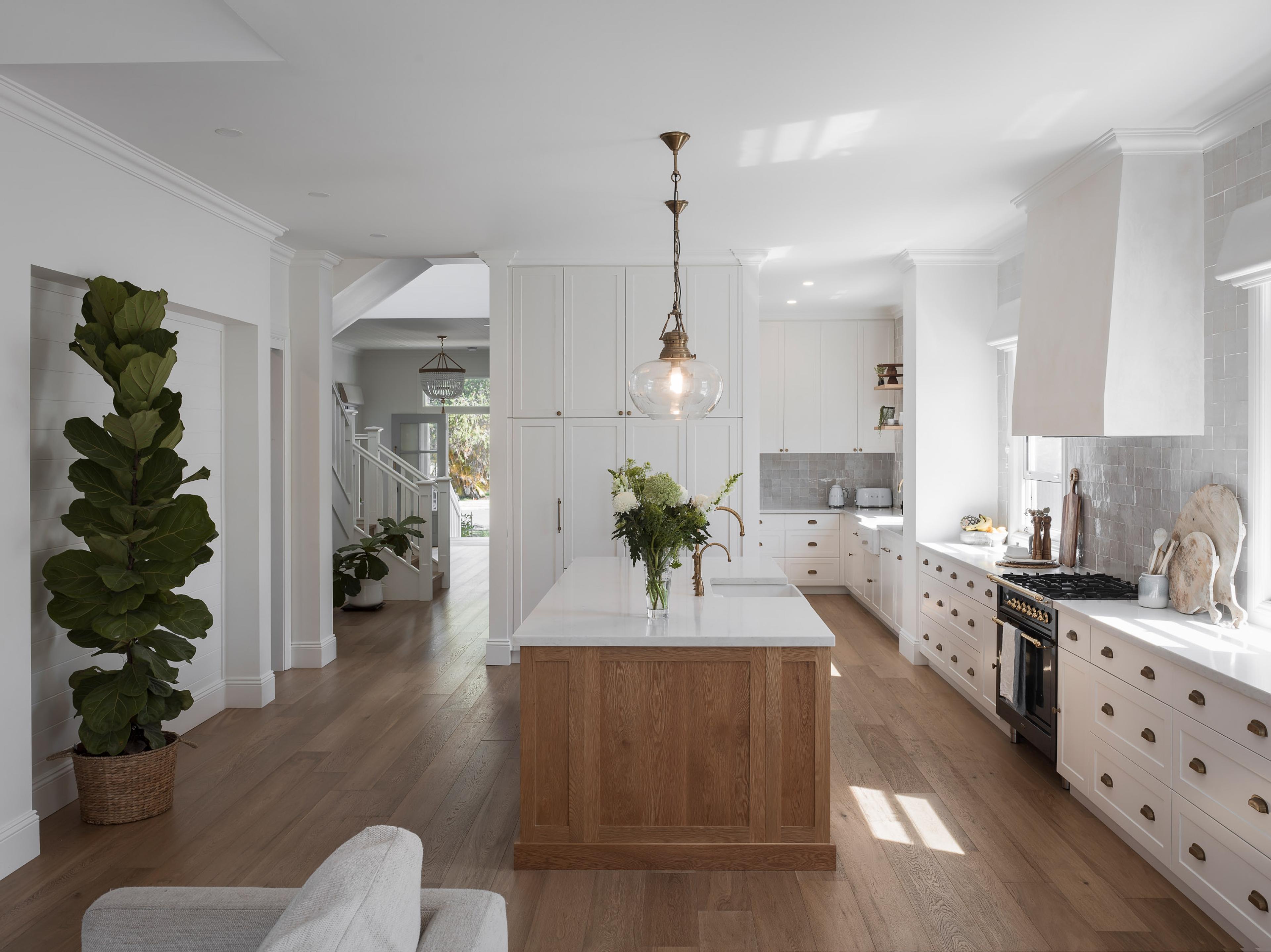 Open plan kitchen with timber island bench and pendant light