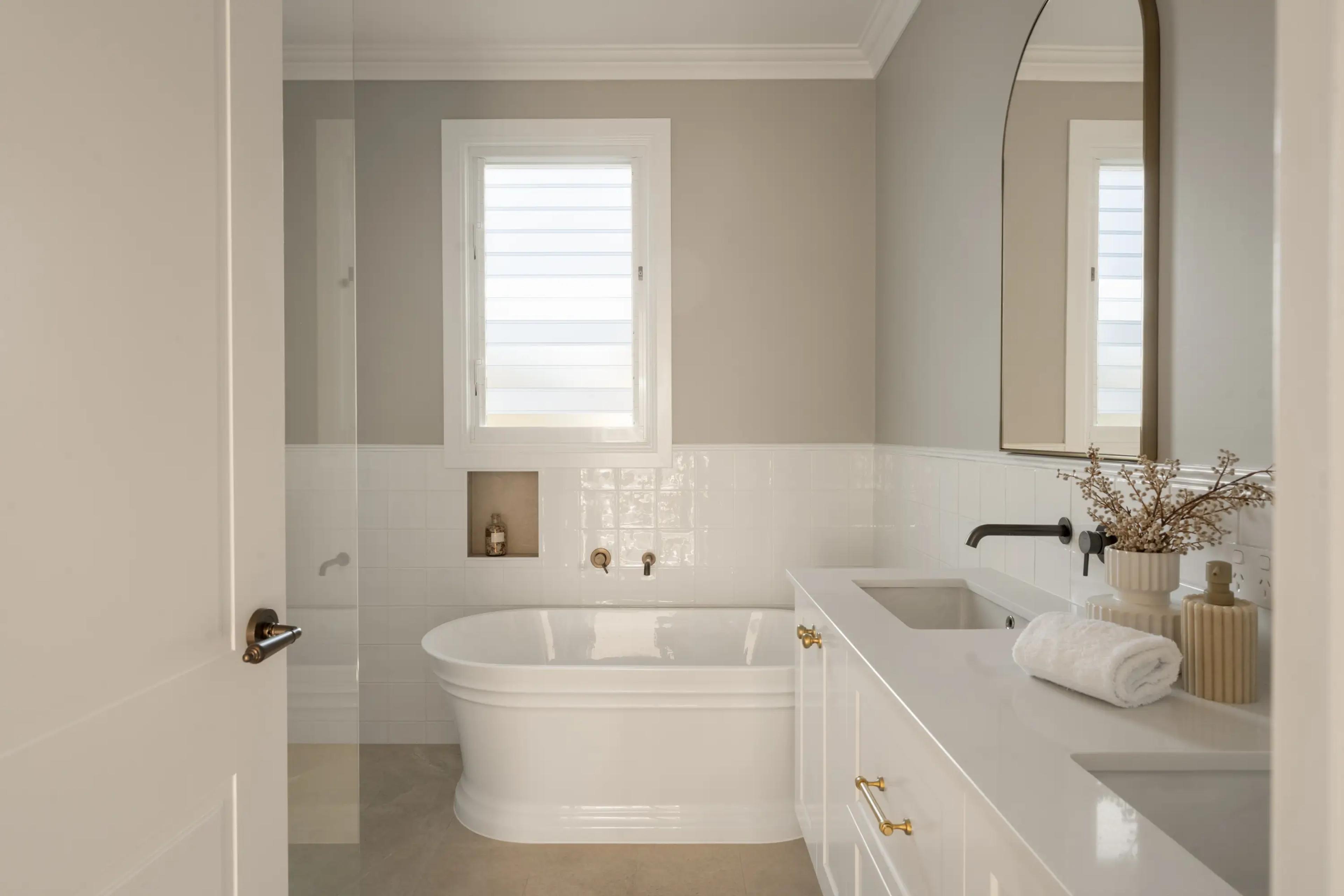 Bathroom with freestanding bath, white vanity and black tapware