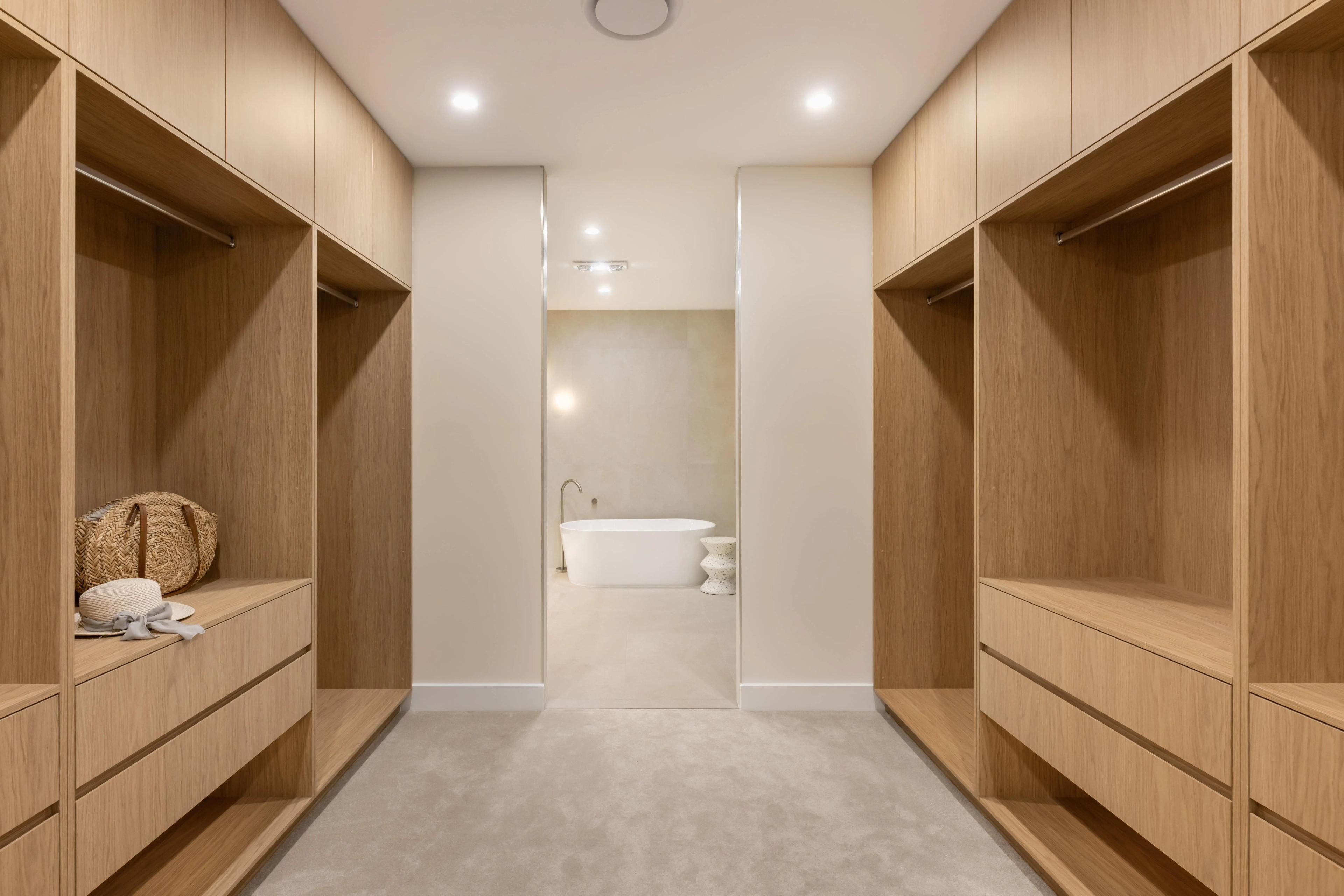 Walk in wardrobe with timber joinery leading to ensuite