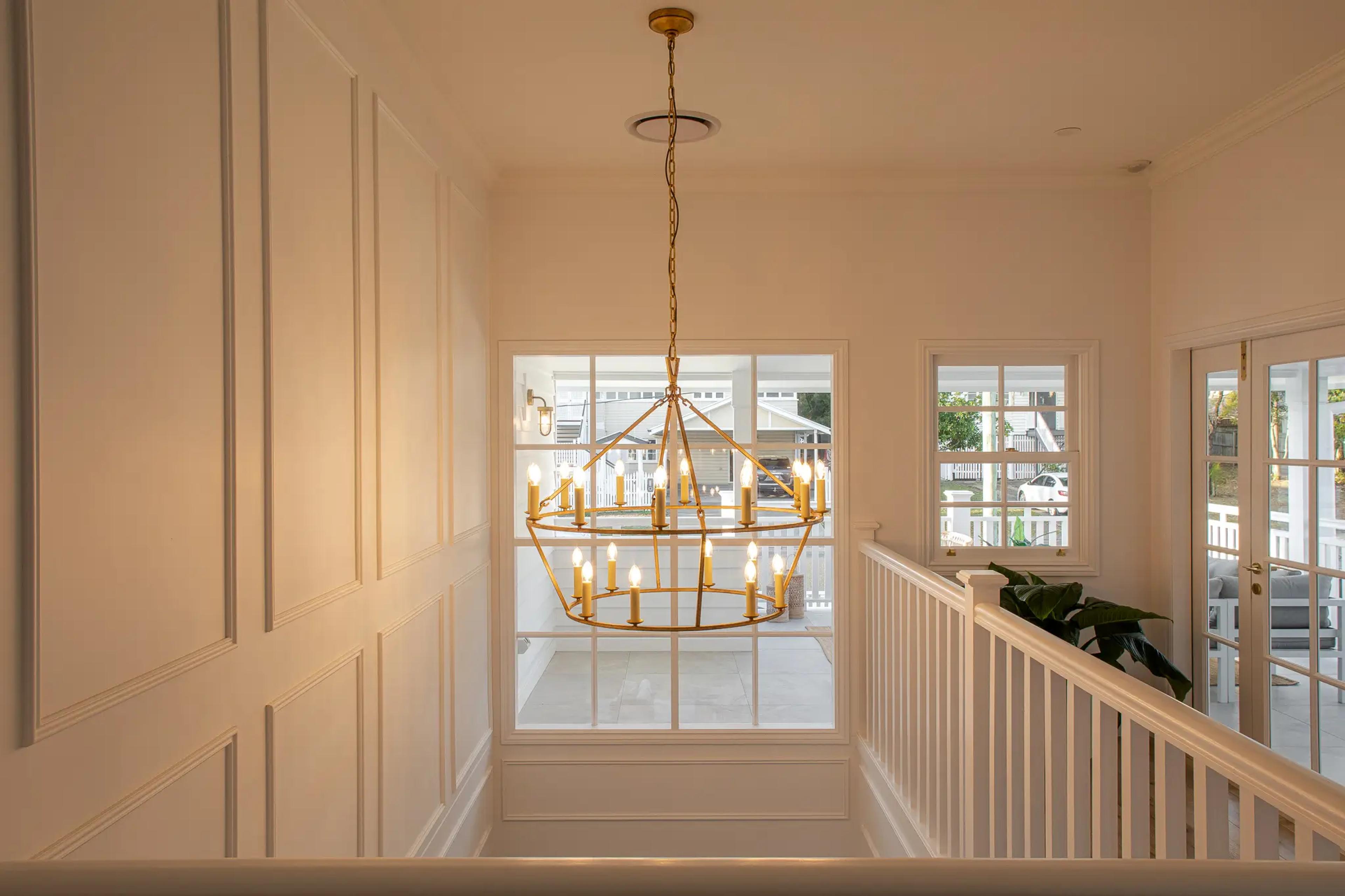 Upstairs landing with brass chandelier and panelled walls