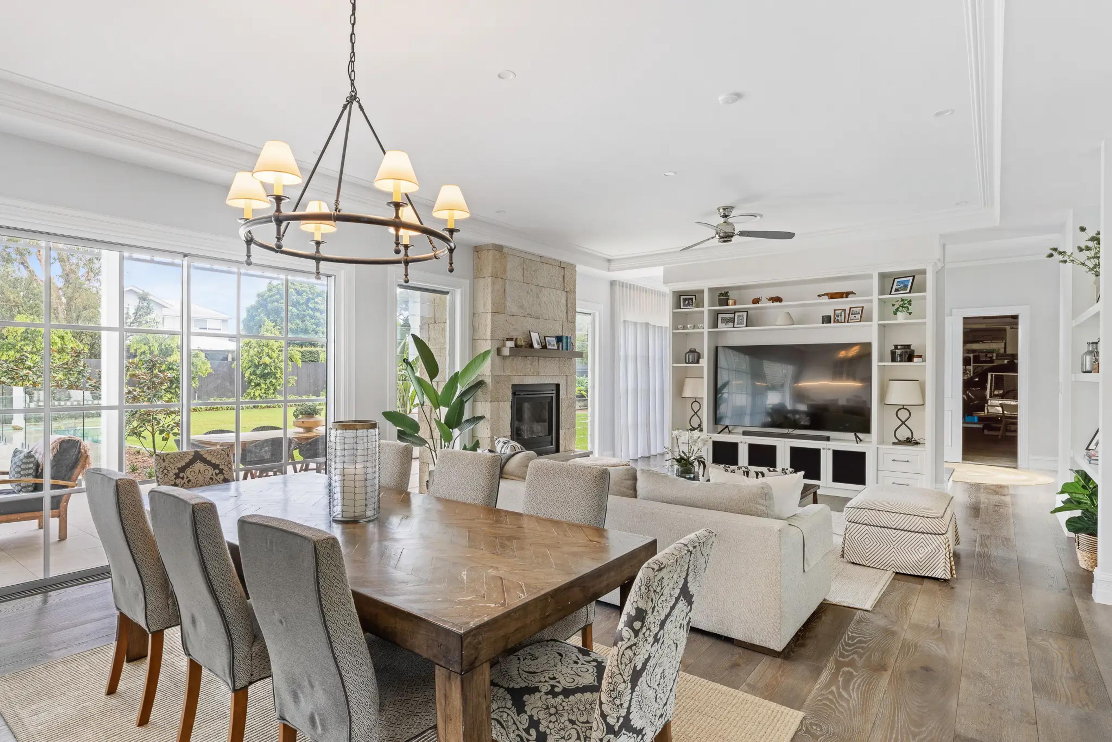 Open plan living and dining area with stone fireplace and large windows