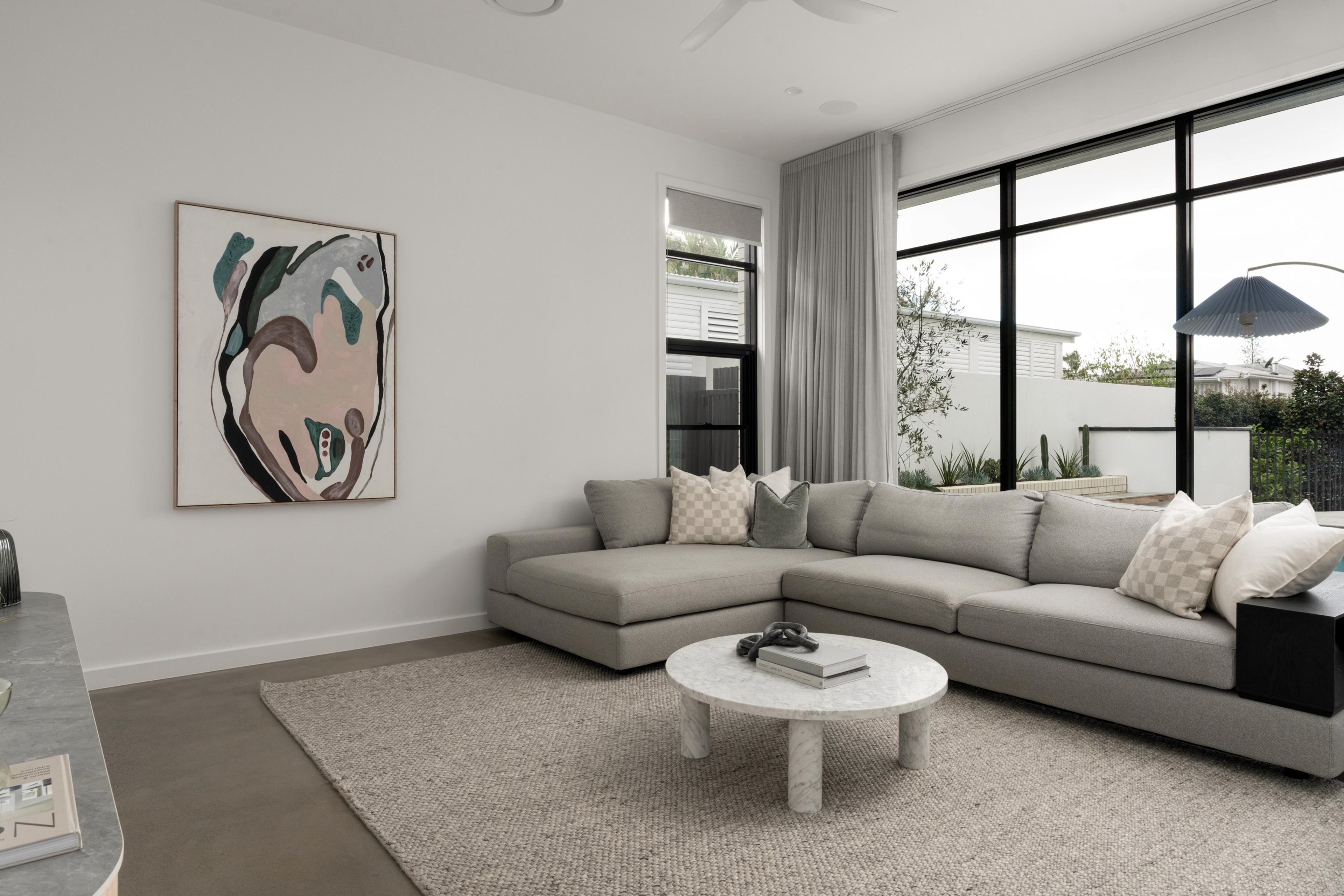 Sitting room with grey sofa and large corner windows