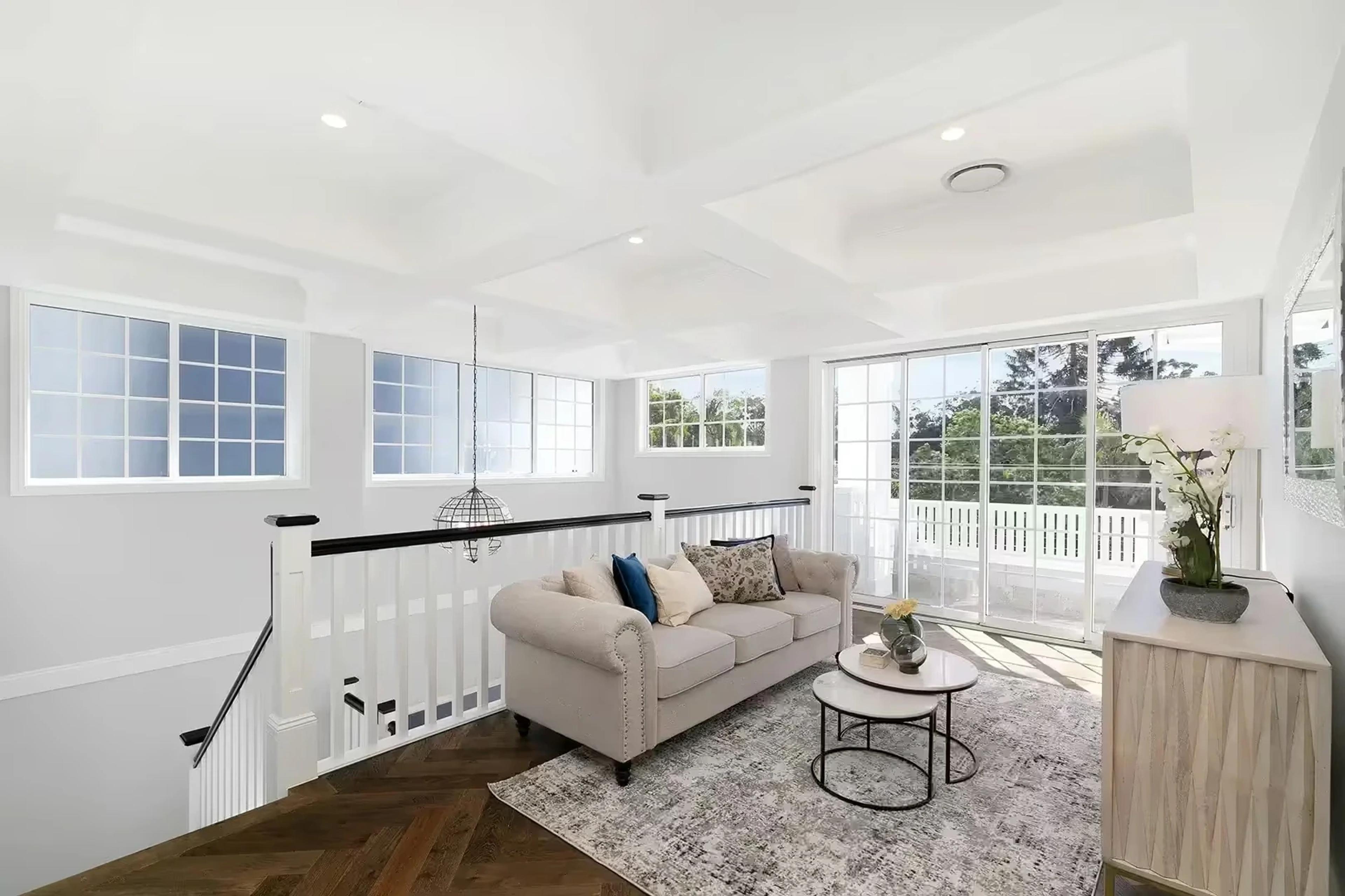 Upstairs sitting area beside staircase with balcony doors