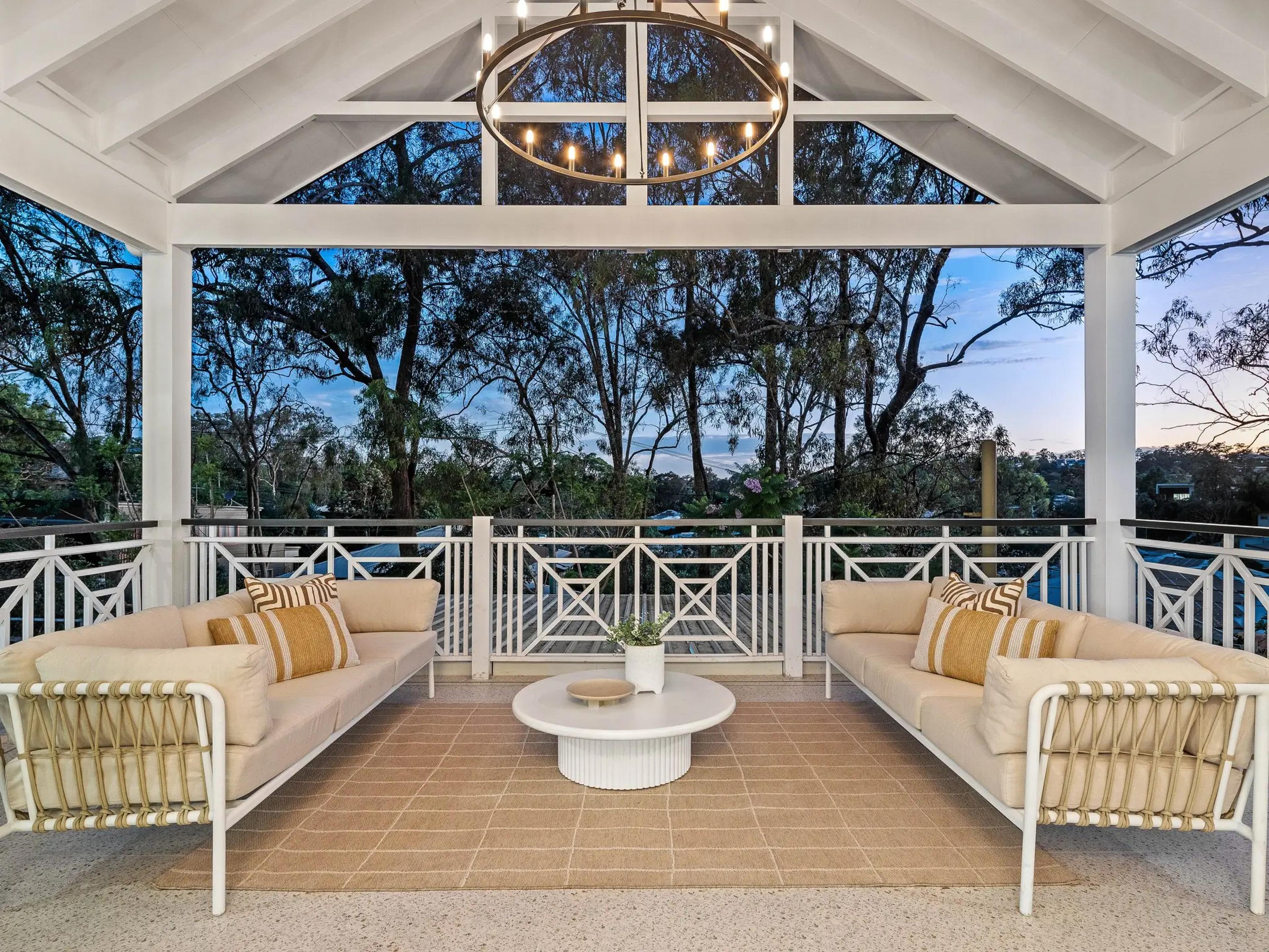 Covered balcony seating with treetop views at dusk