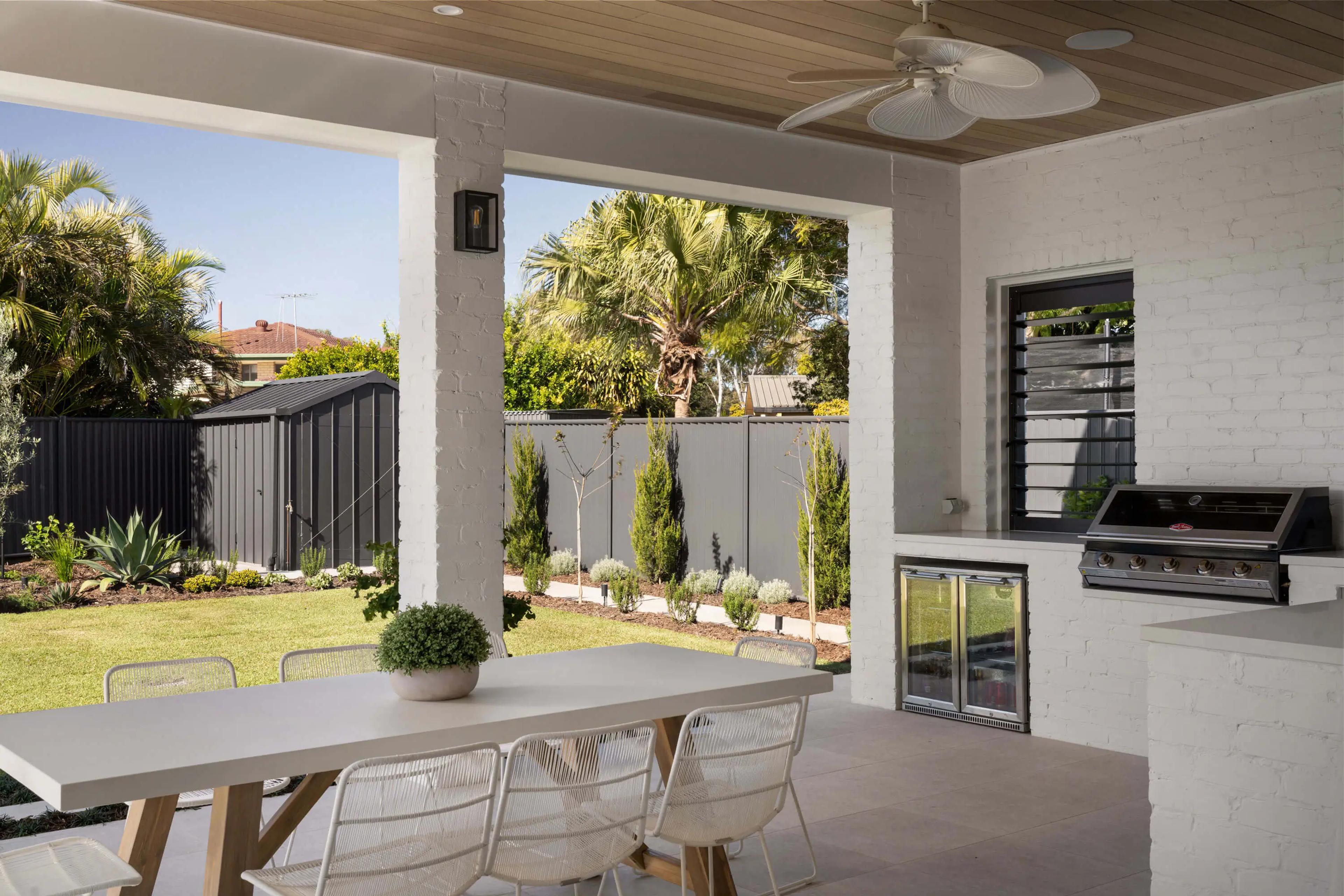 Covered alfresco area with dining table and built in barbecue