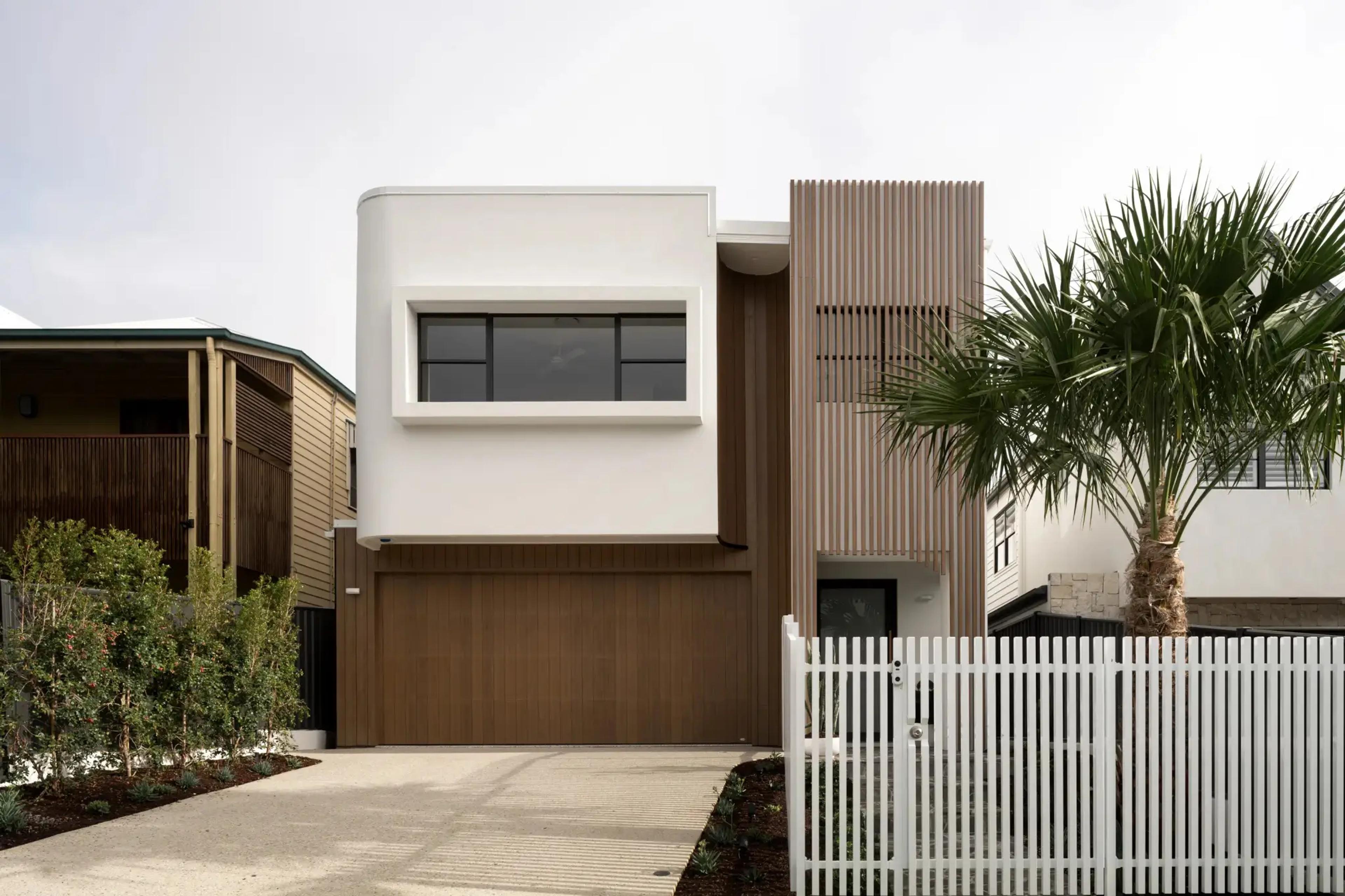 Street facing home facade with garage and white fence
