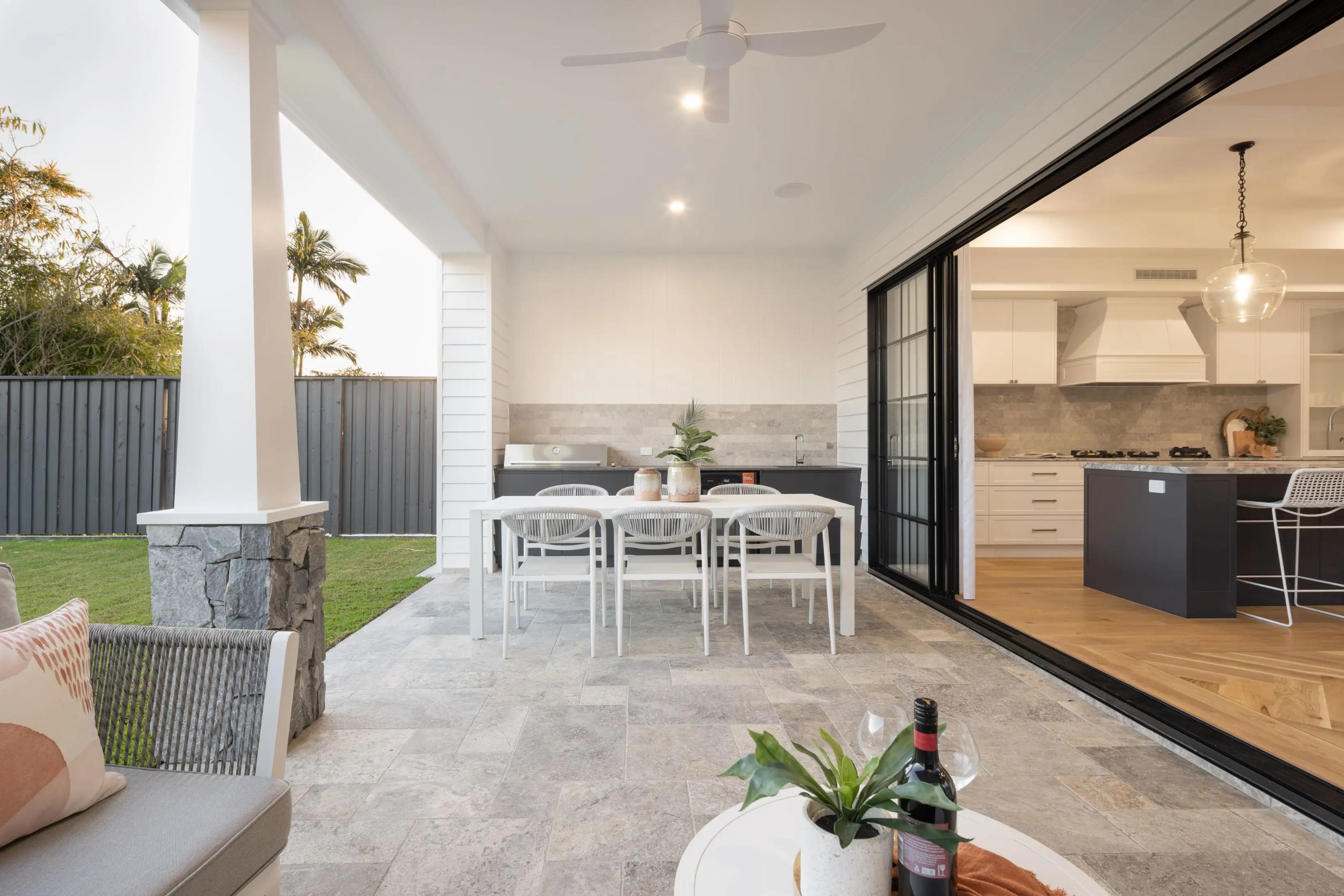 Covered outdoor dining area with kitchen views and stone garden