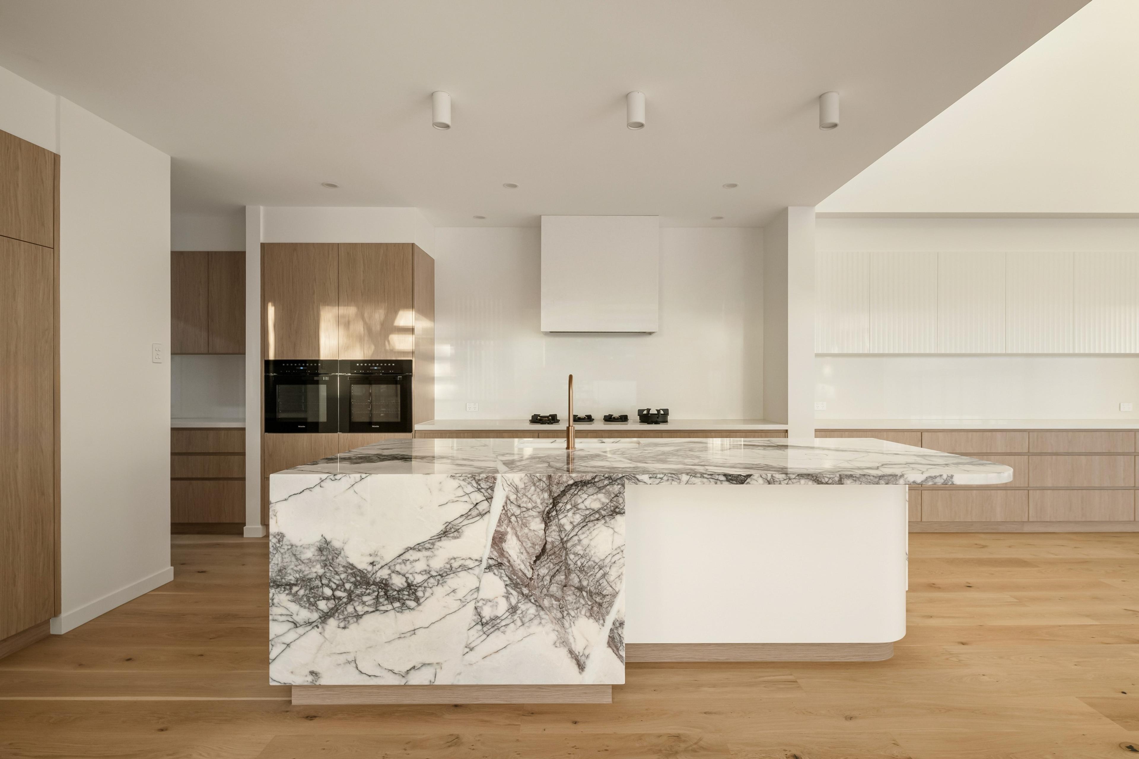 Modern kitchen with veined marble island and timber cabinetry