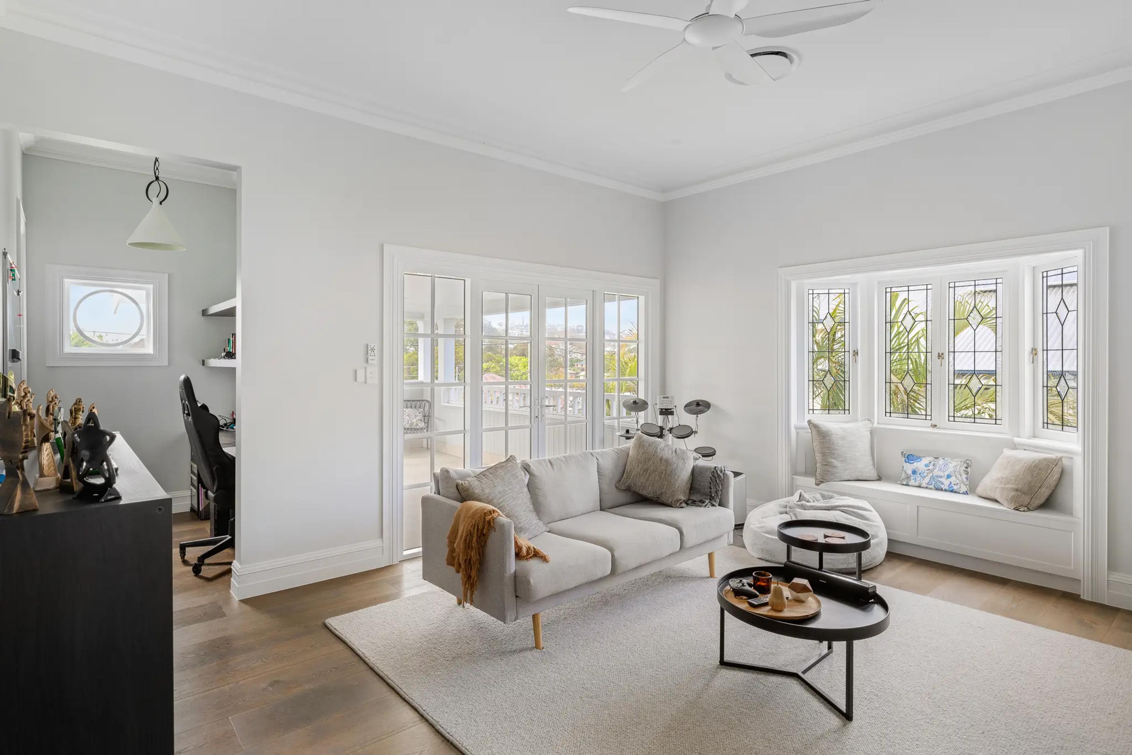 Upstairs sitting room with grey sofa and leadlight bay window seat