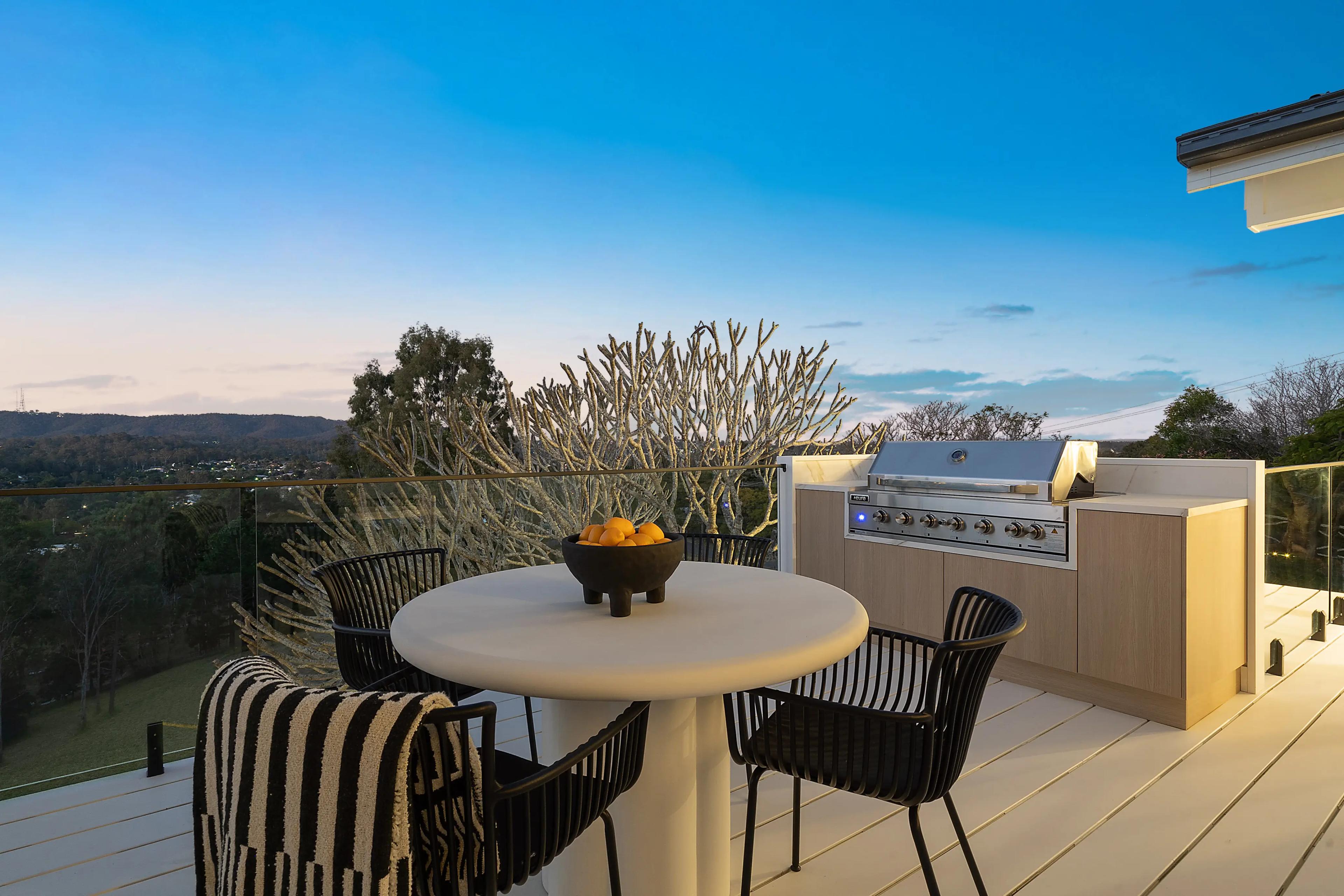 Outdoor deck with built-in barbecue, dining table and valley views.