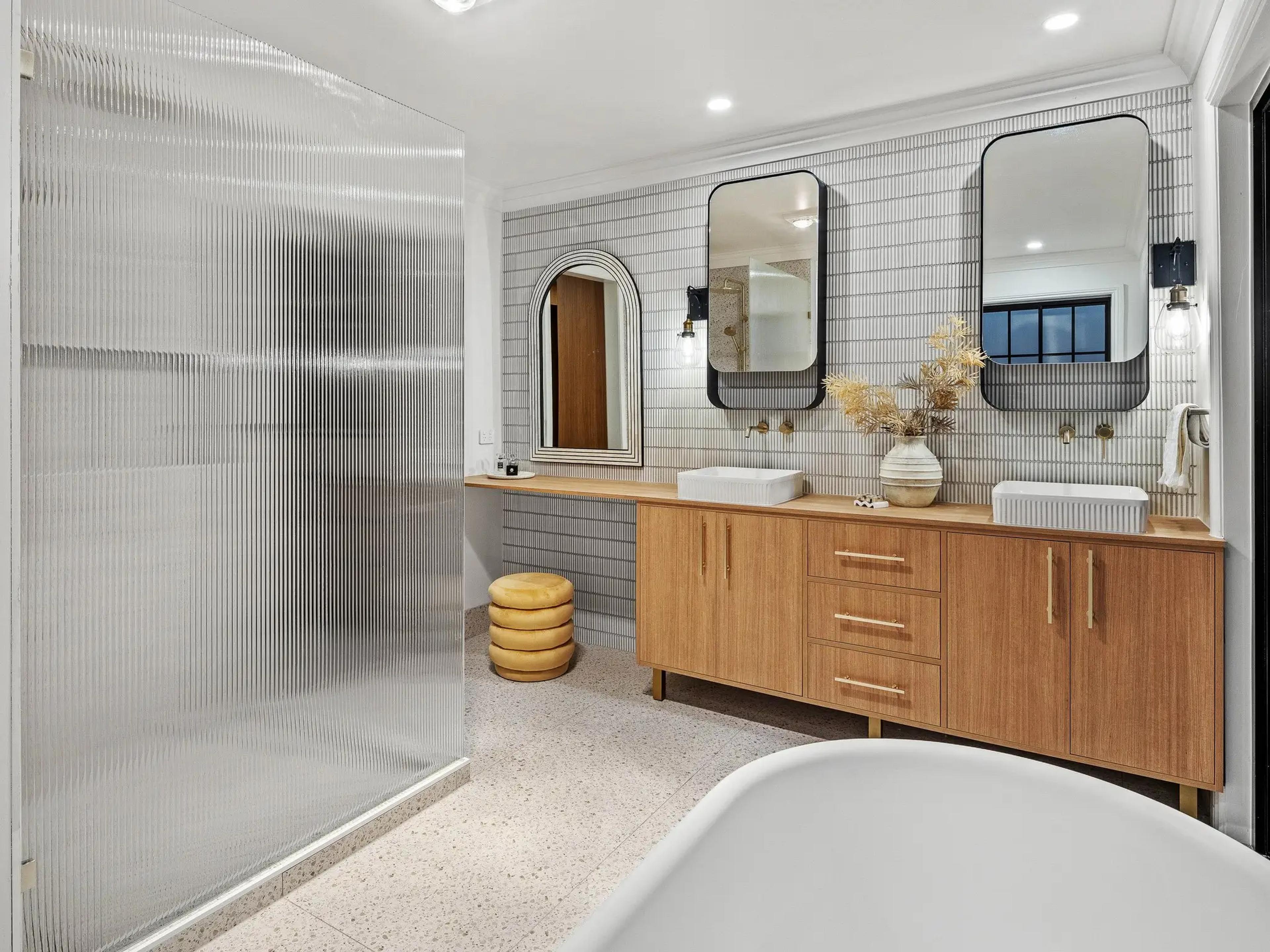 Bathroom with double vanity and fluted glass shower