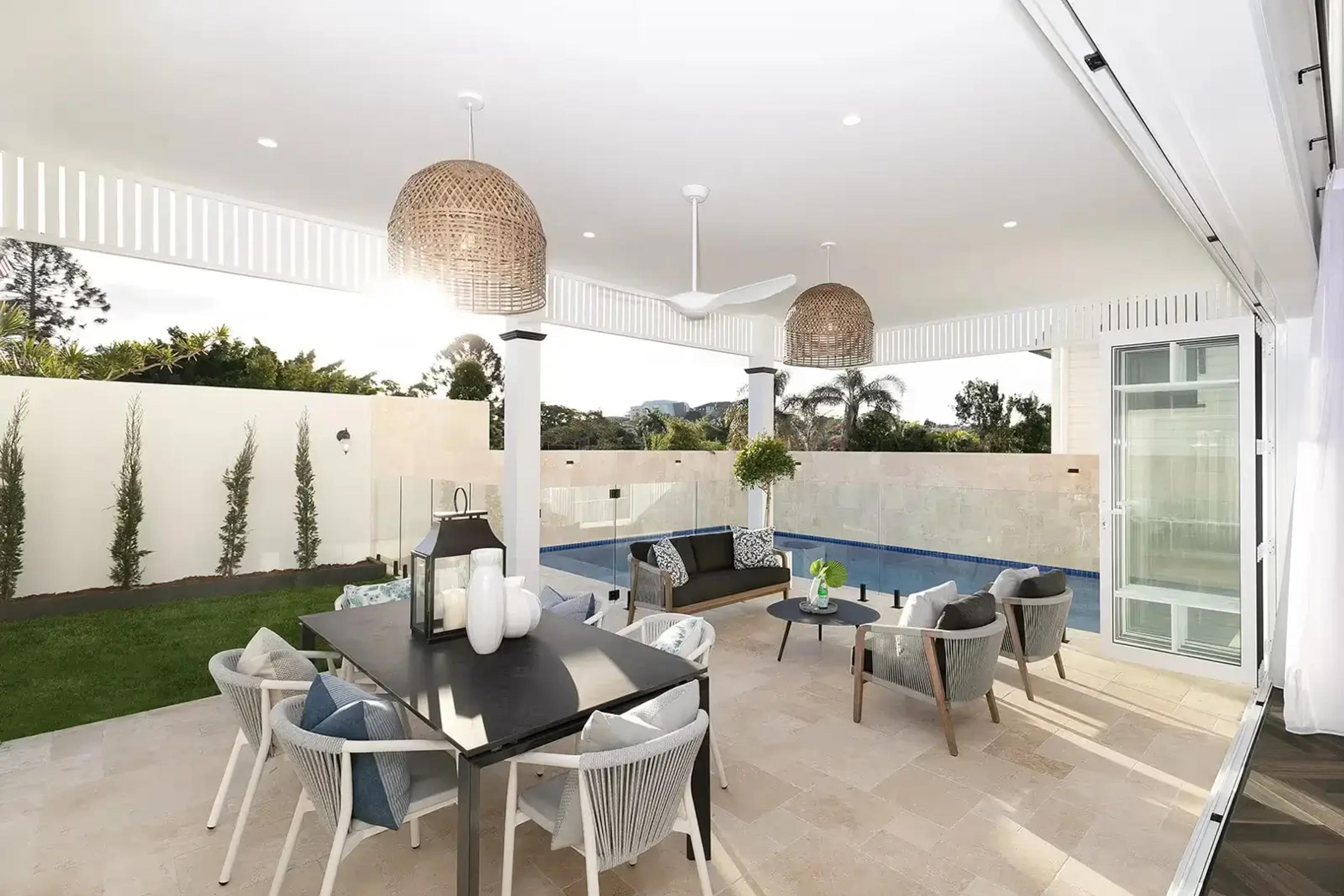 Covered alfresco dining and lounge area beside swimming pool