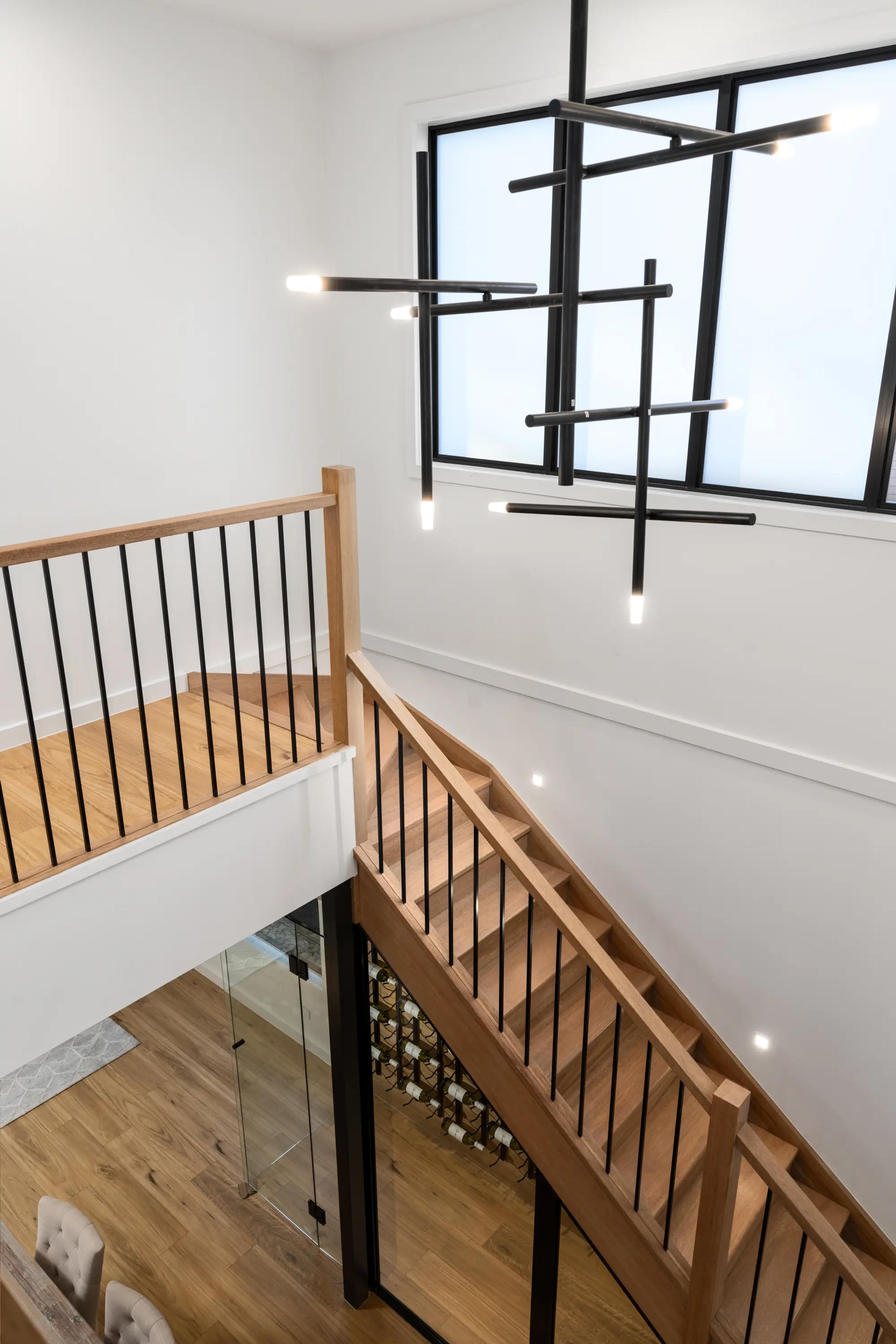 Timber staircase void with sculptural black pendant light