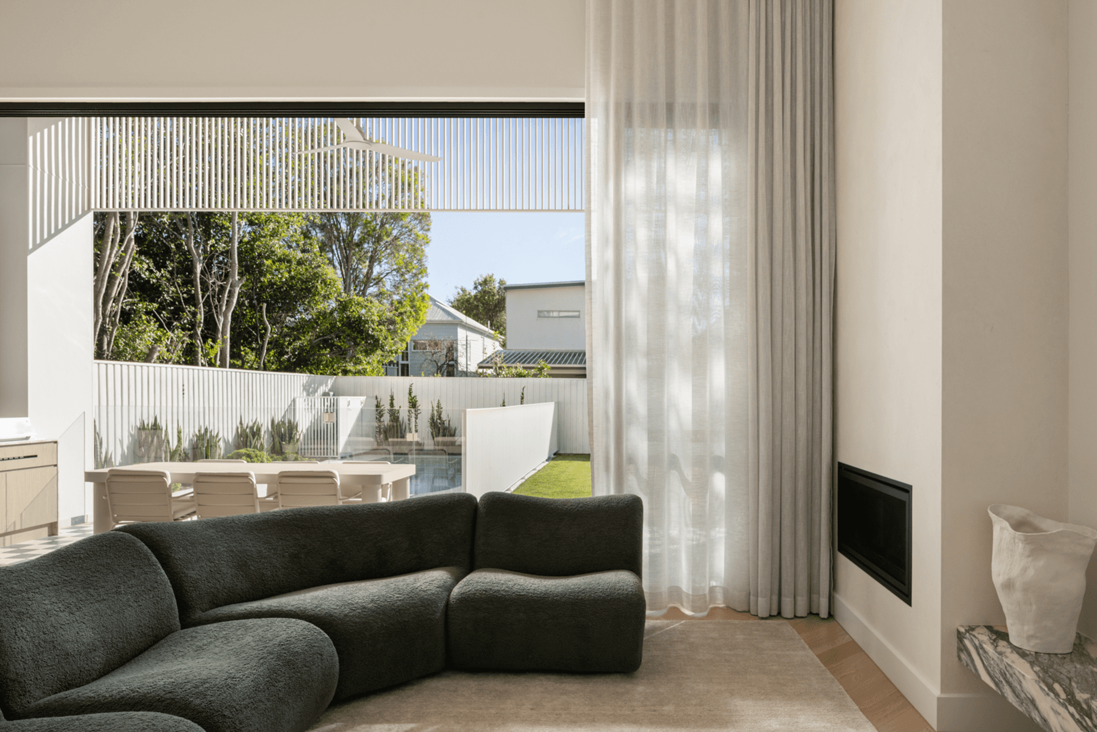 Living room with curved sofa and view to pool