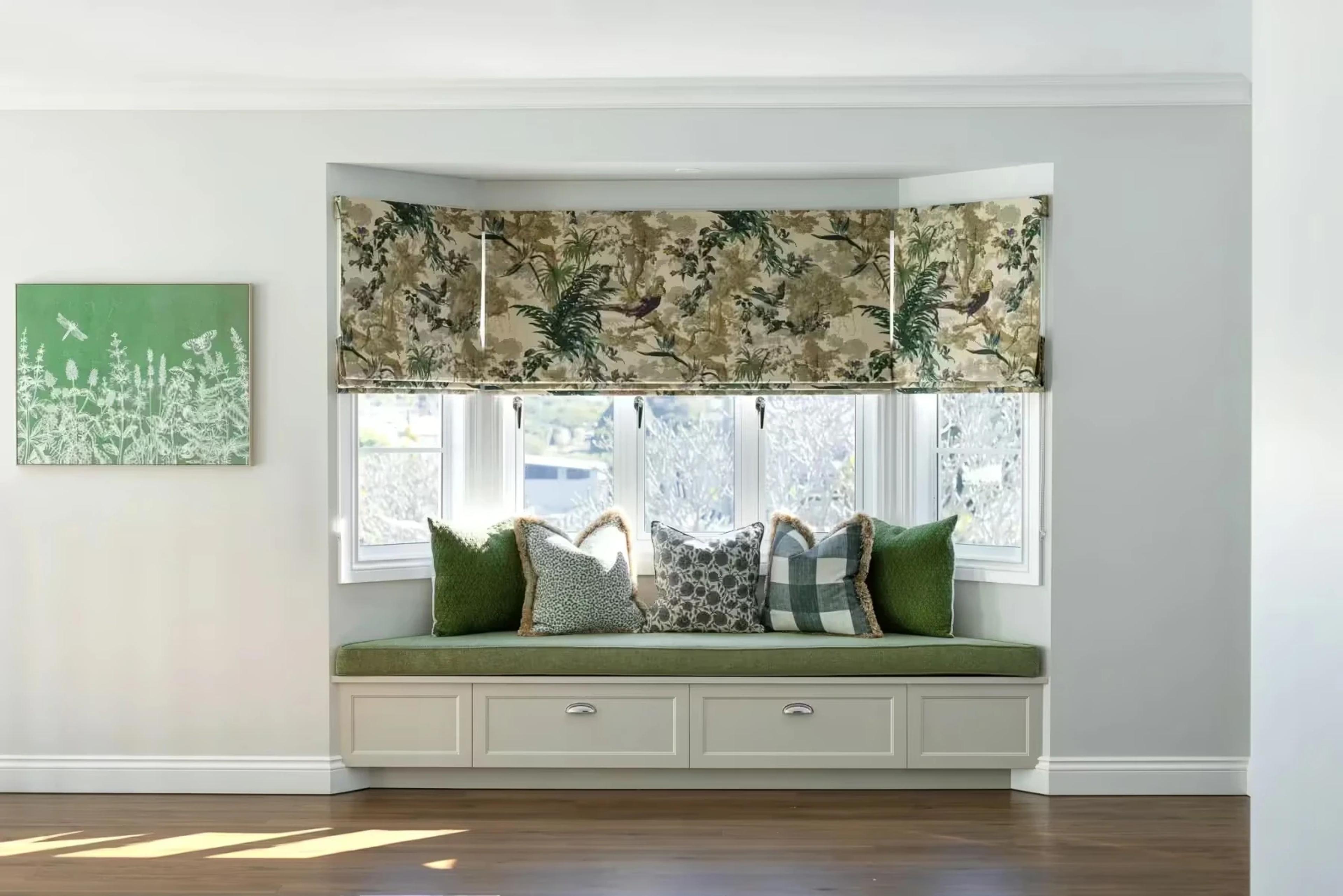 Bay window bench seat with patterned cushions and roman blind