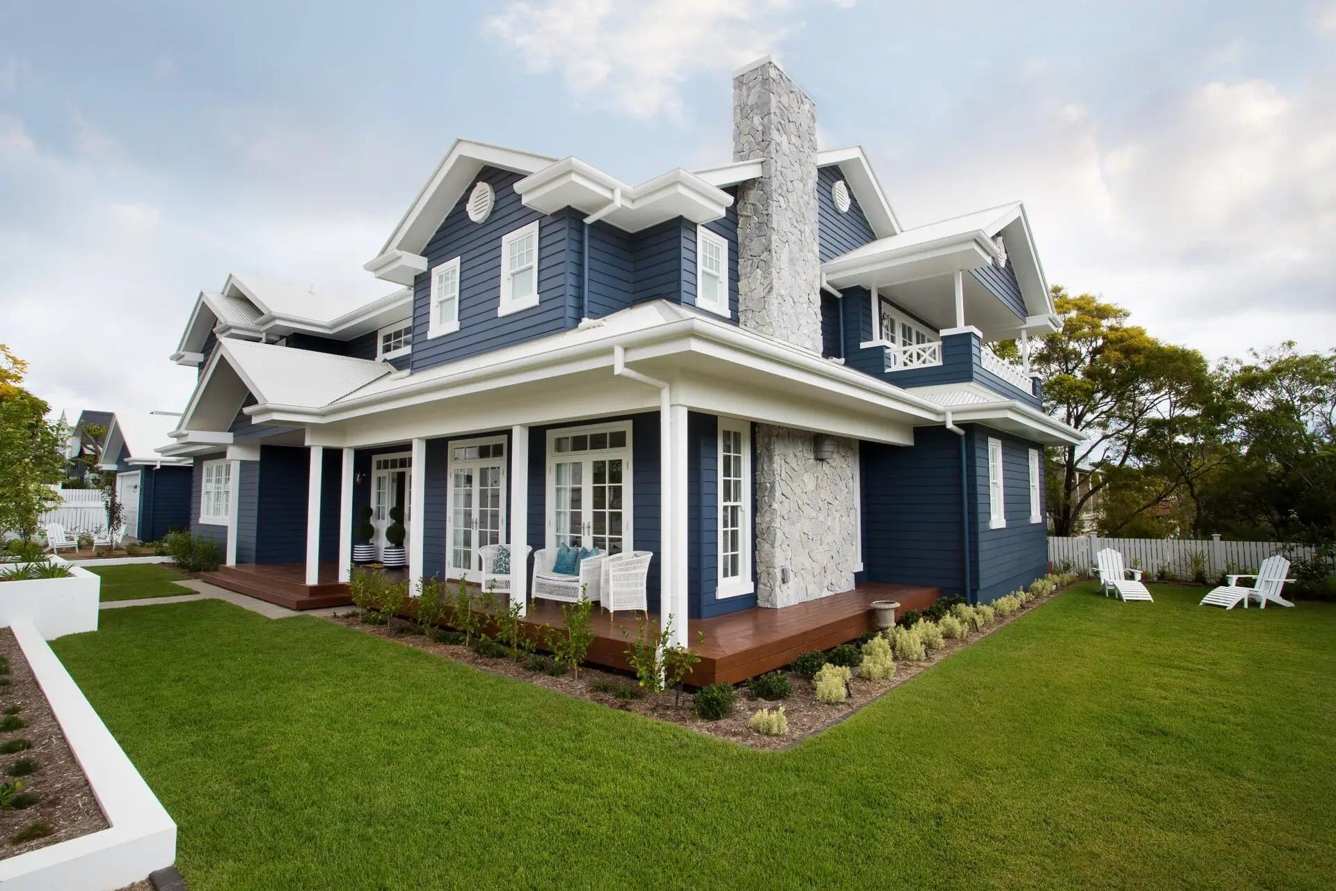Navy weatherboard Hamptons home front exterior with wraparound verandah