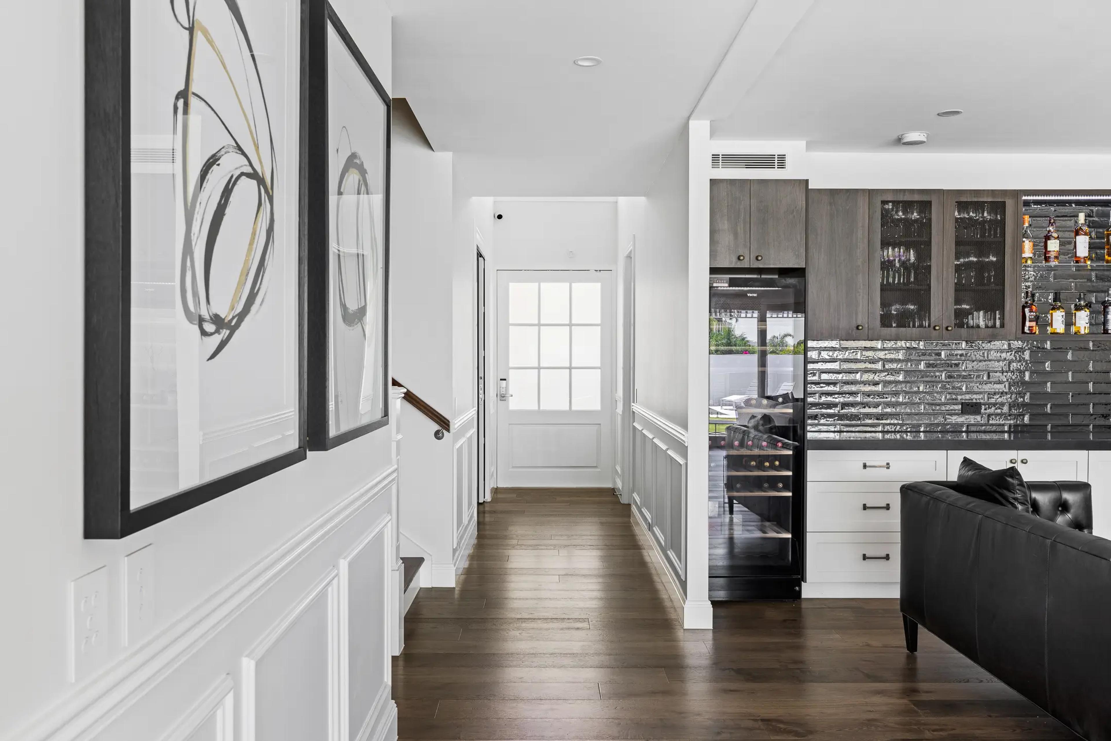 Hallway with wainscoting leading to entrance and bar