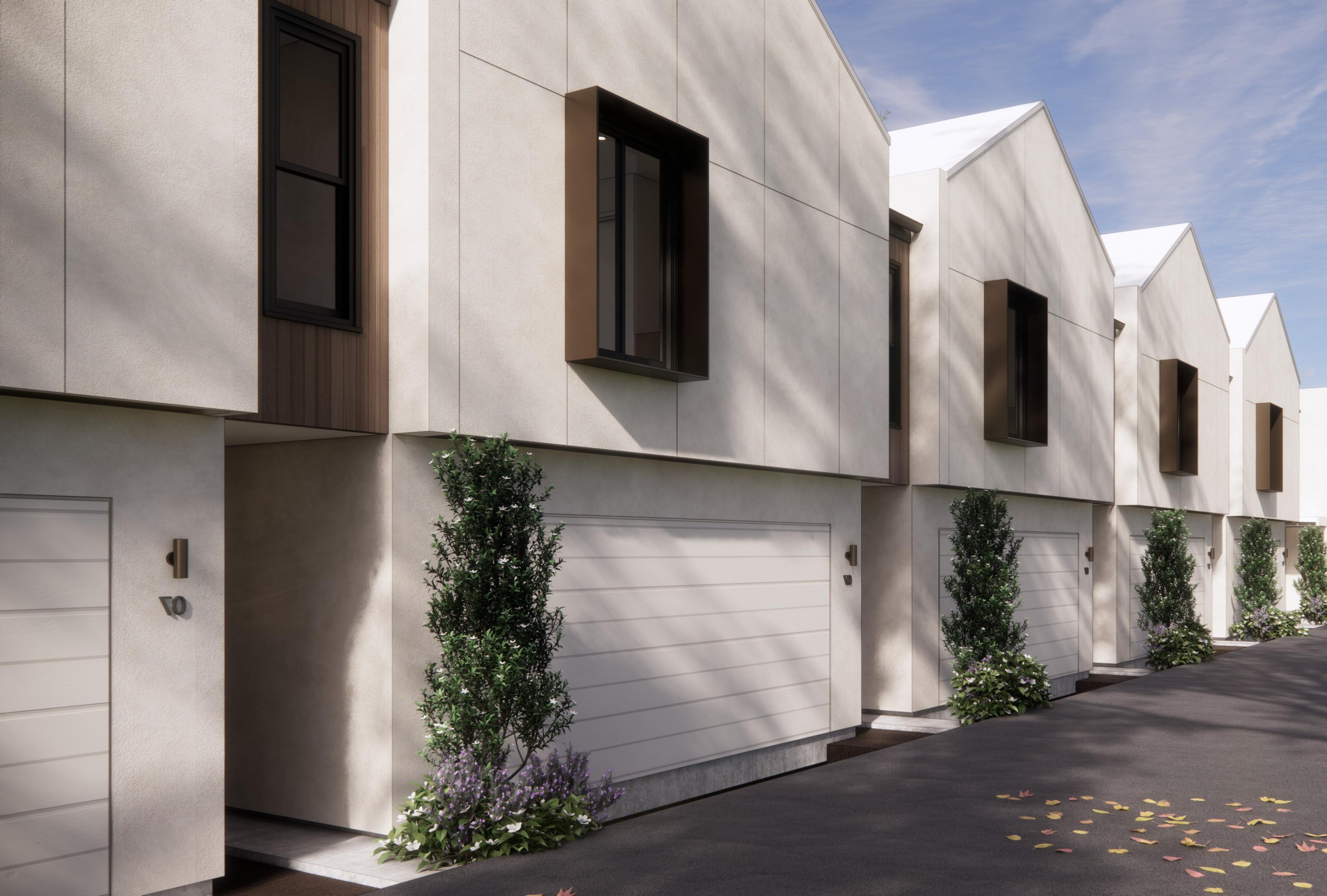Angled view of townhouse facades with landscaped entries