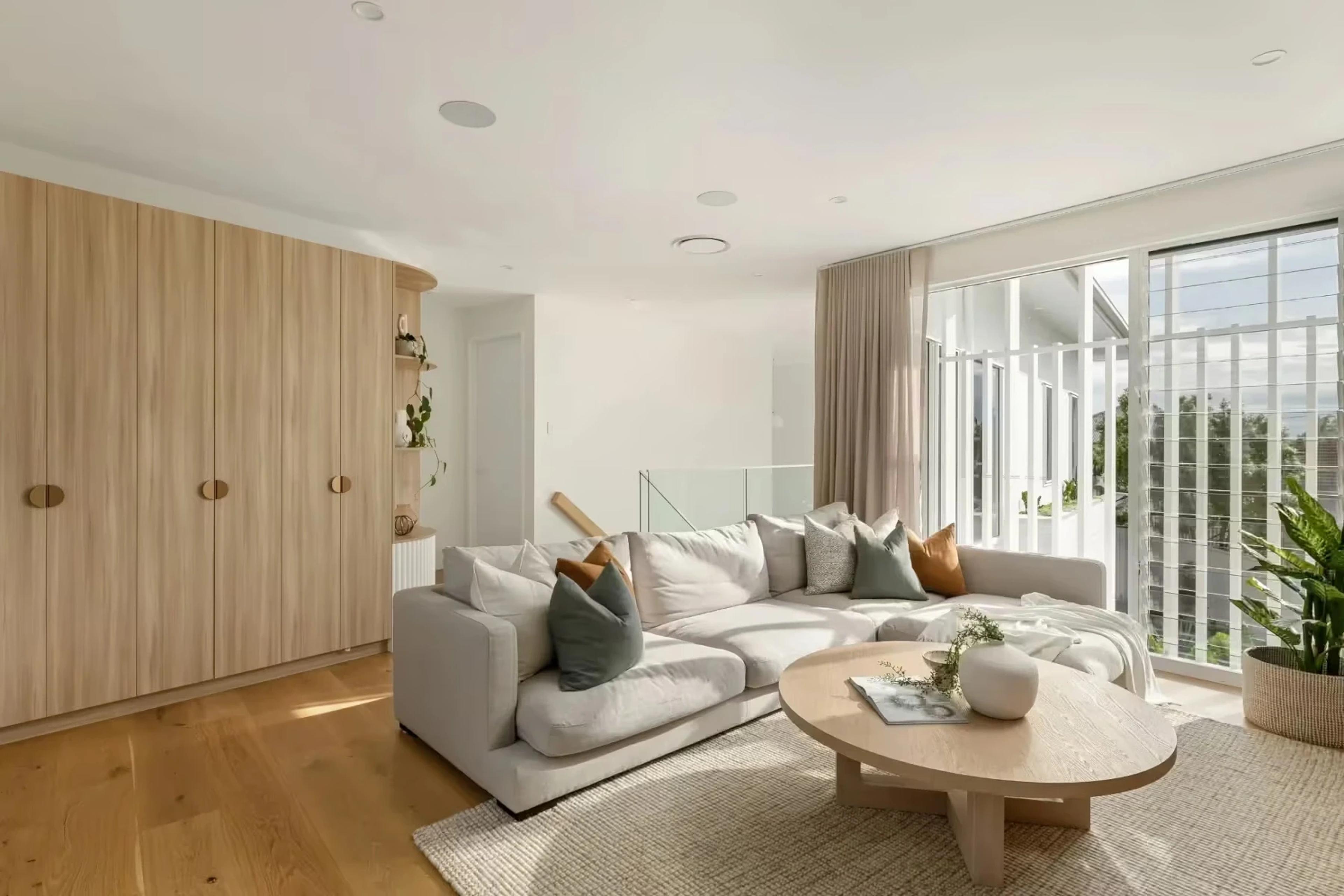 Lounge room with timber joinery and floor to ceiling windows