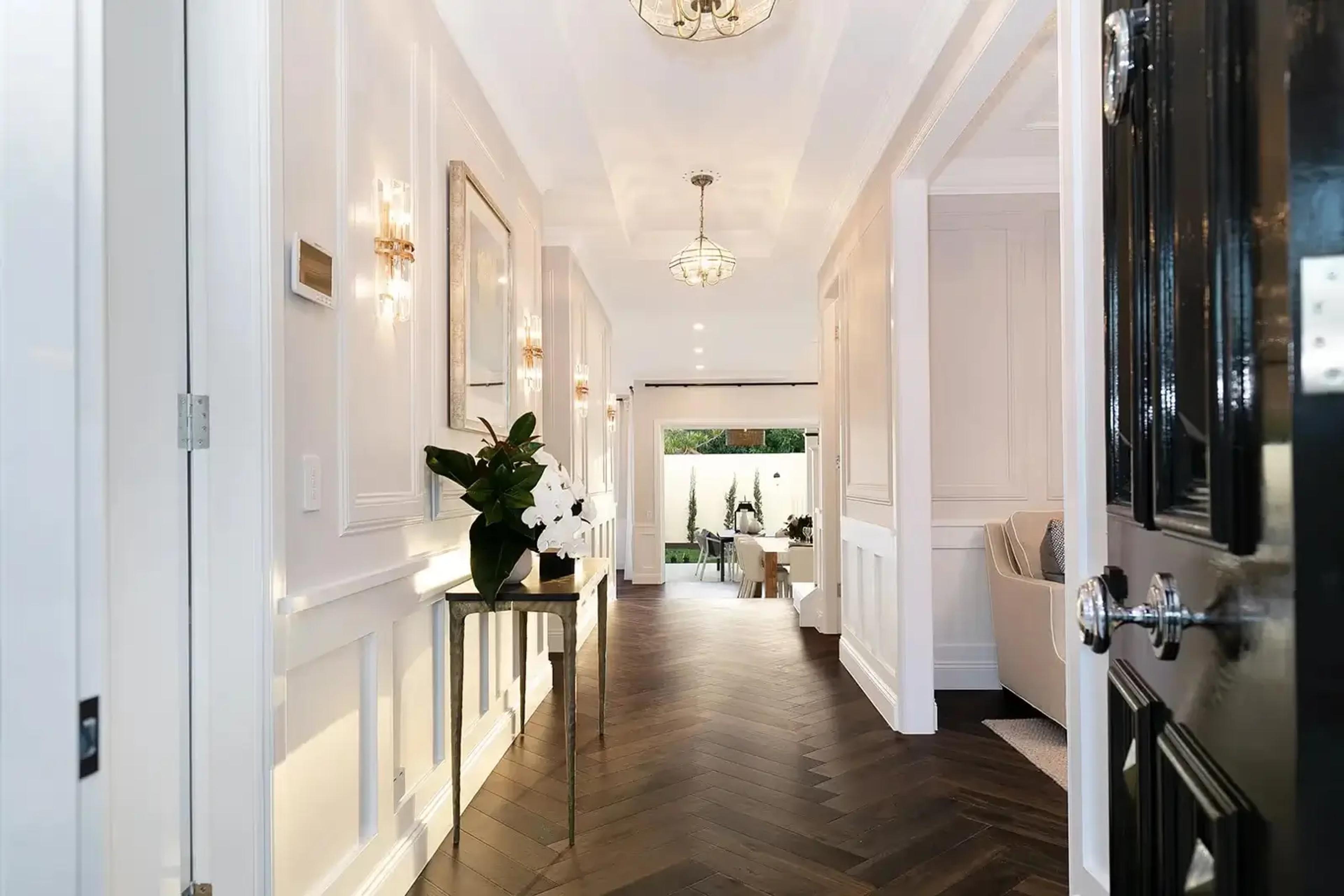 Panelled entry hallway with herringbone timber floor and console table
