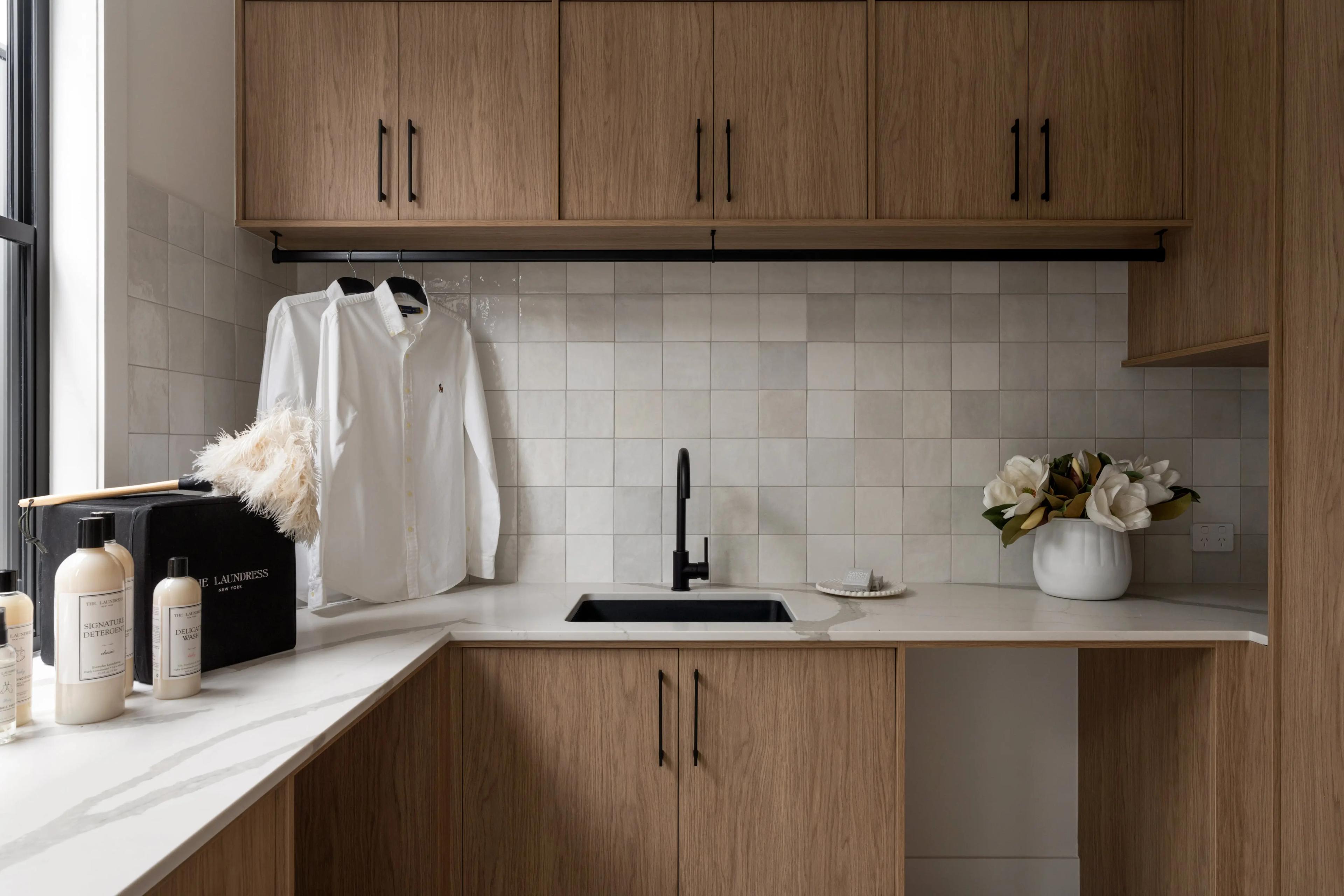 Laundry with timber cabinetry, stone bench and sink
