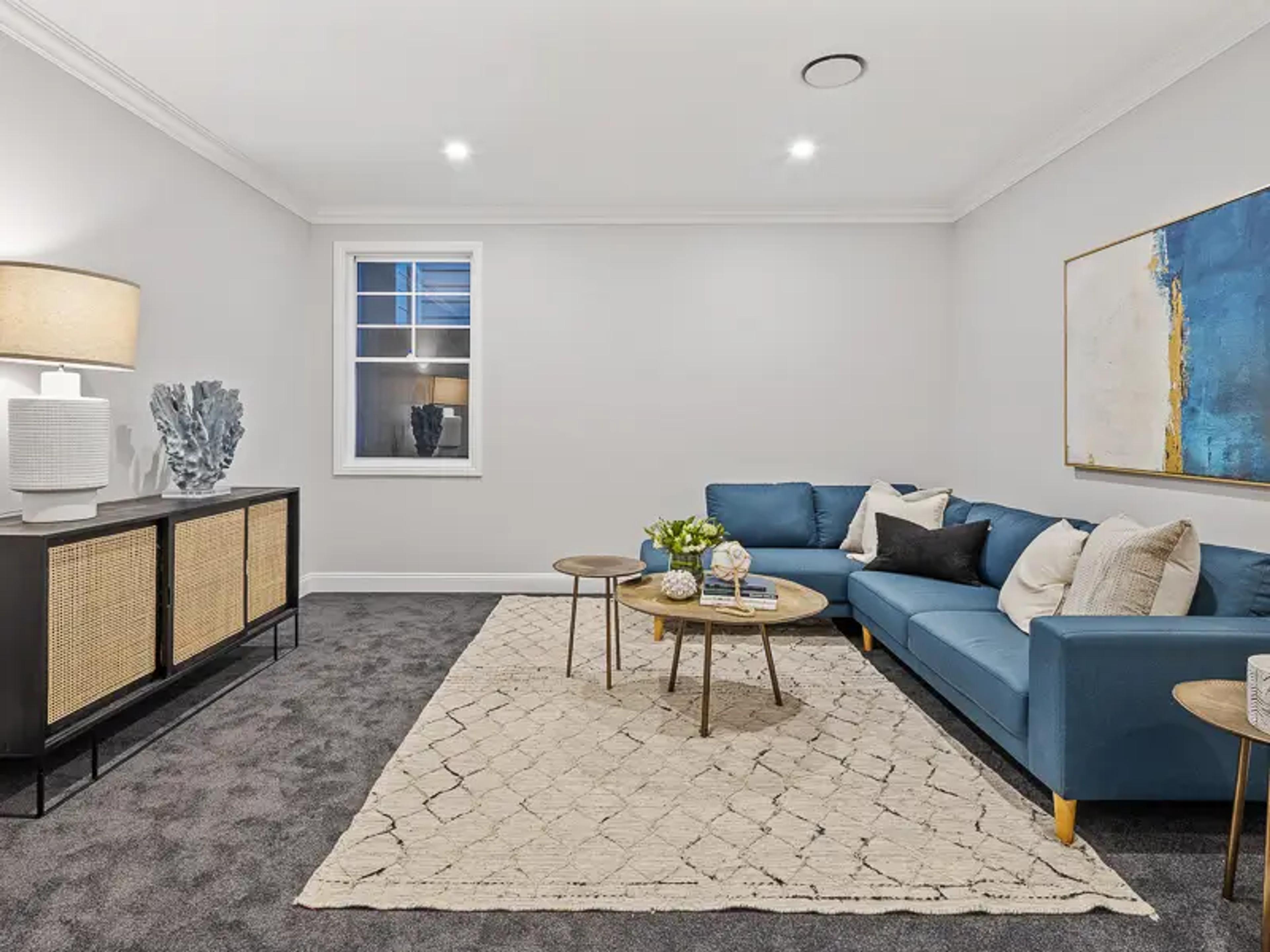 Media room with blue sofa, sideboard and abstract wall art