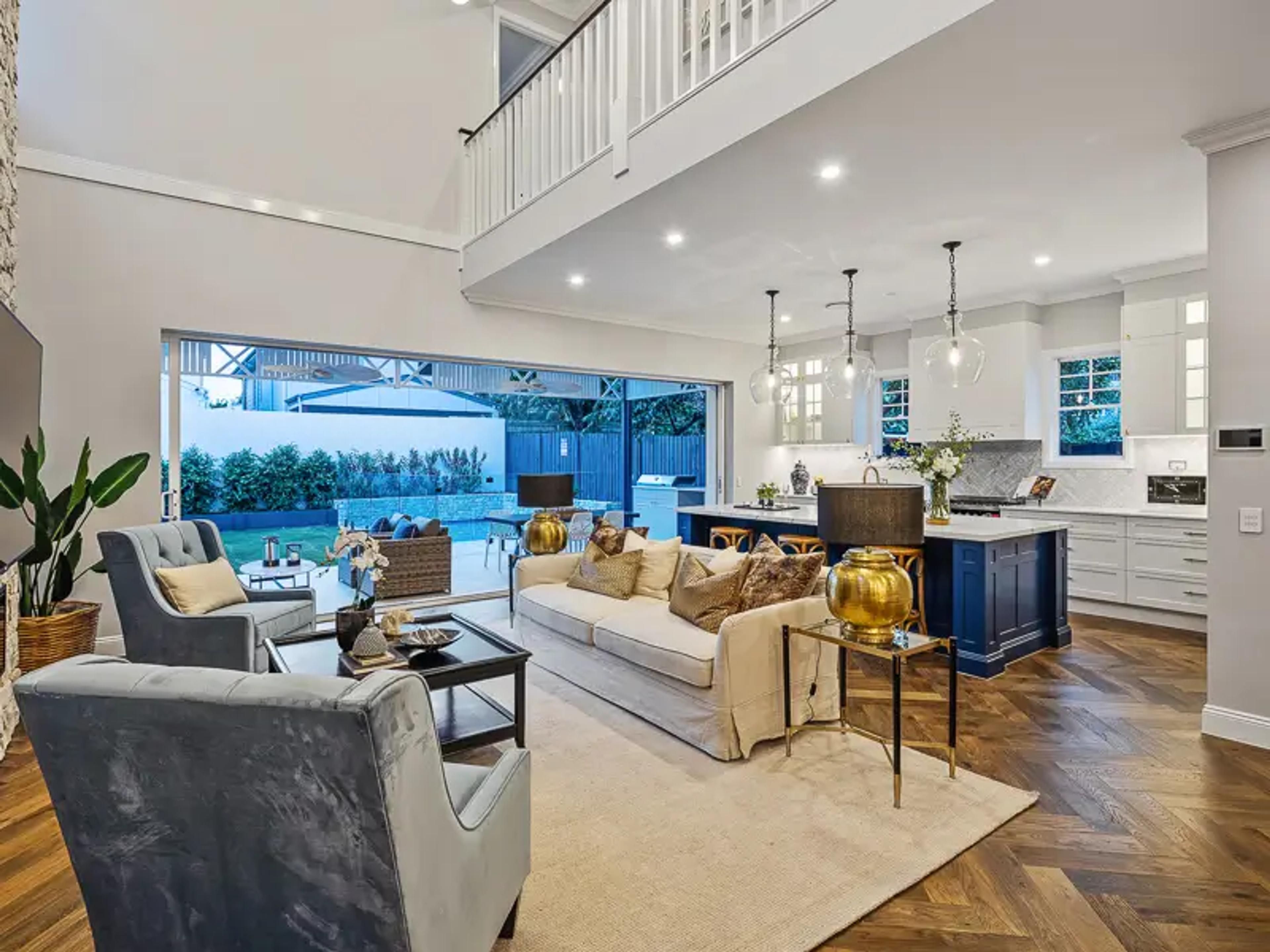 Double height living room with void and blue kitchen island