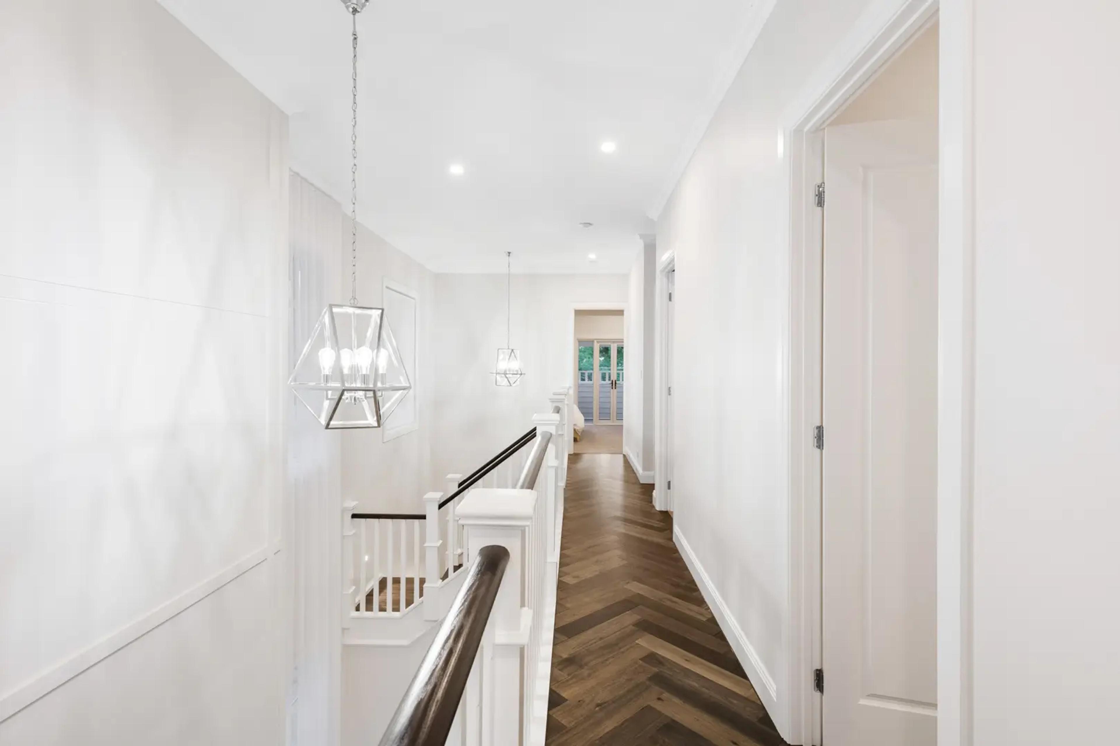 Upstairs hallway with pendant lights and timber floor