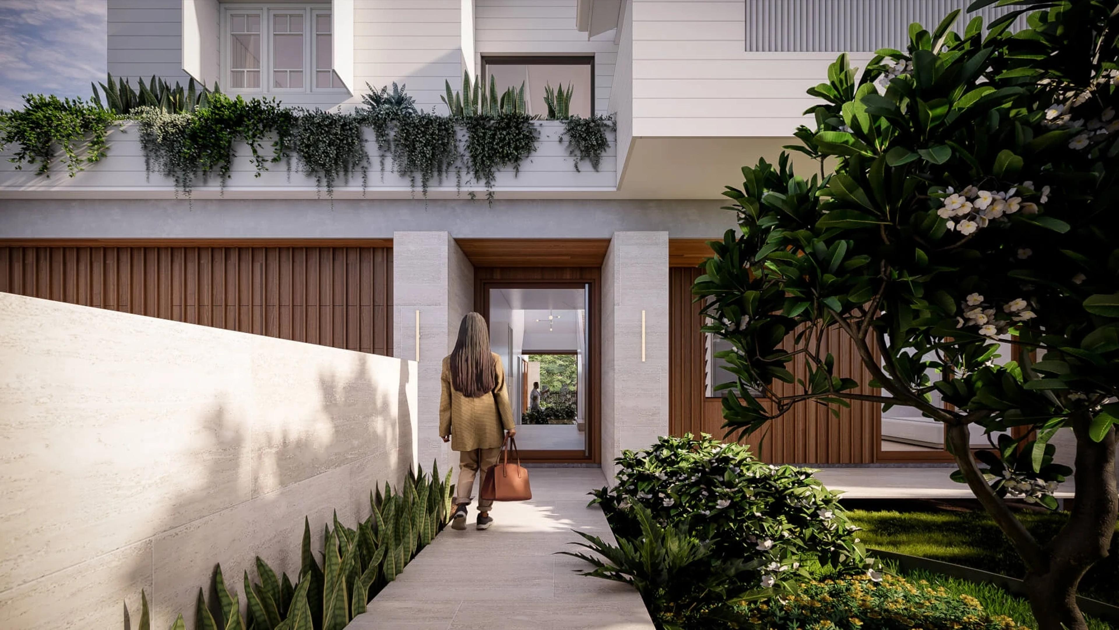 Person walking along landscaped entry path to timber front door