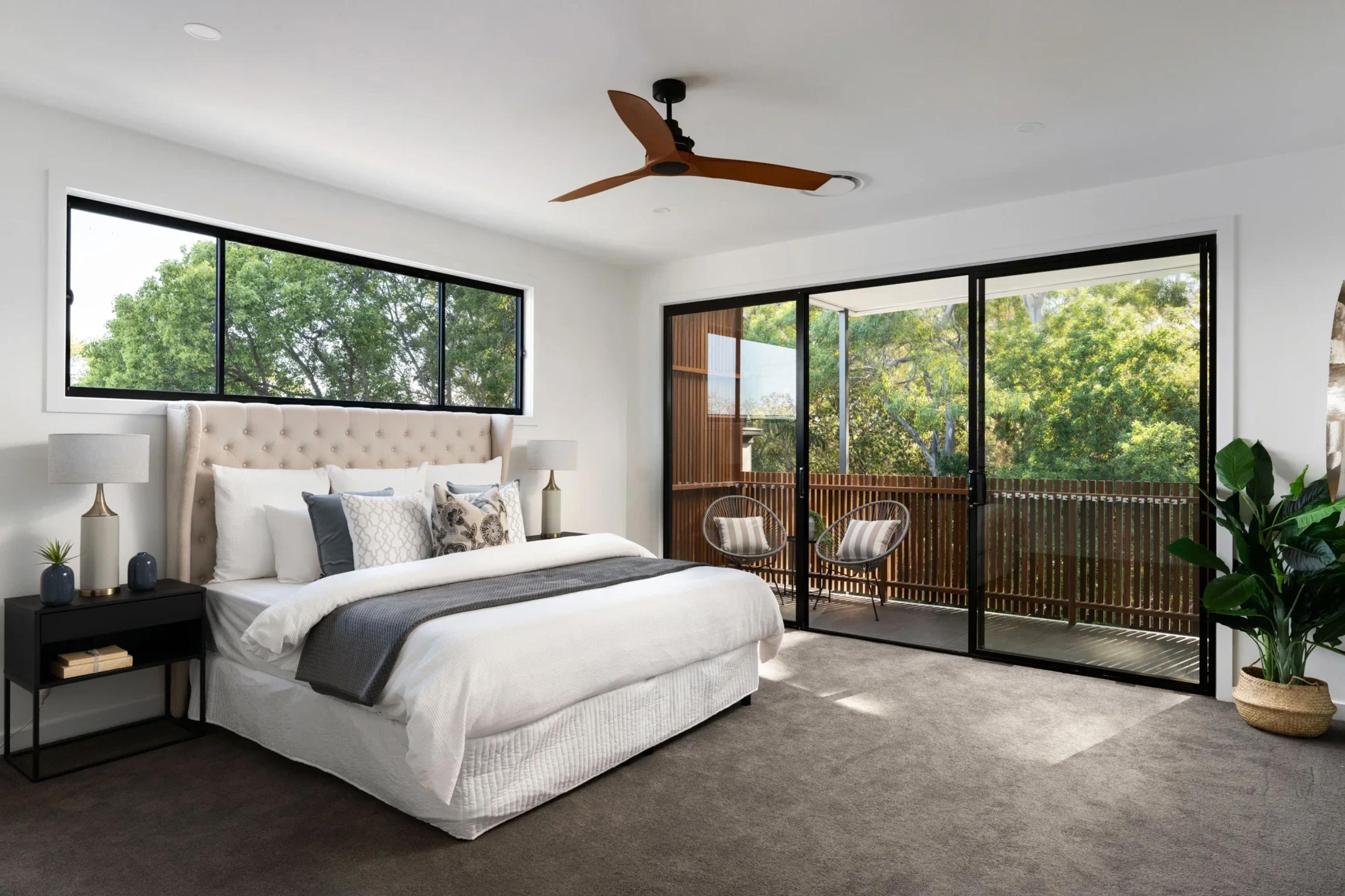Bedroom with balcony access and leafy treetop views
