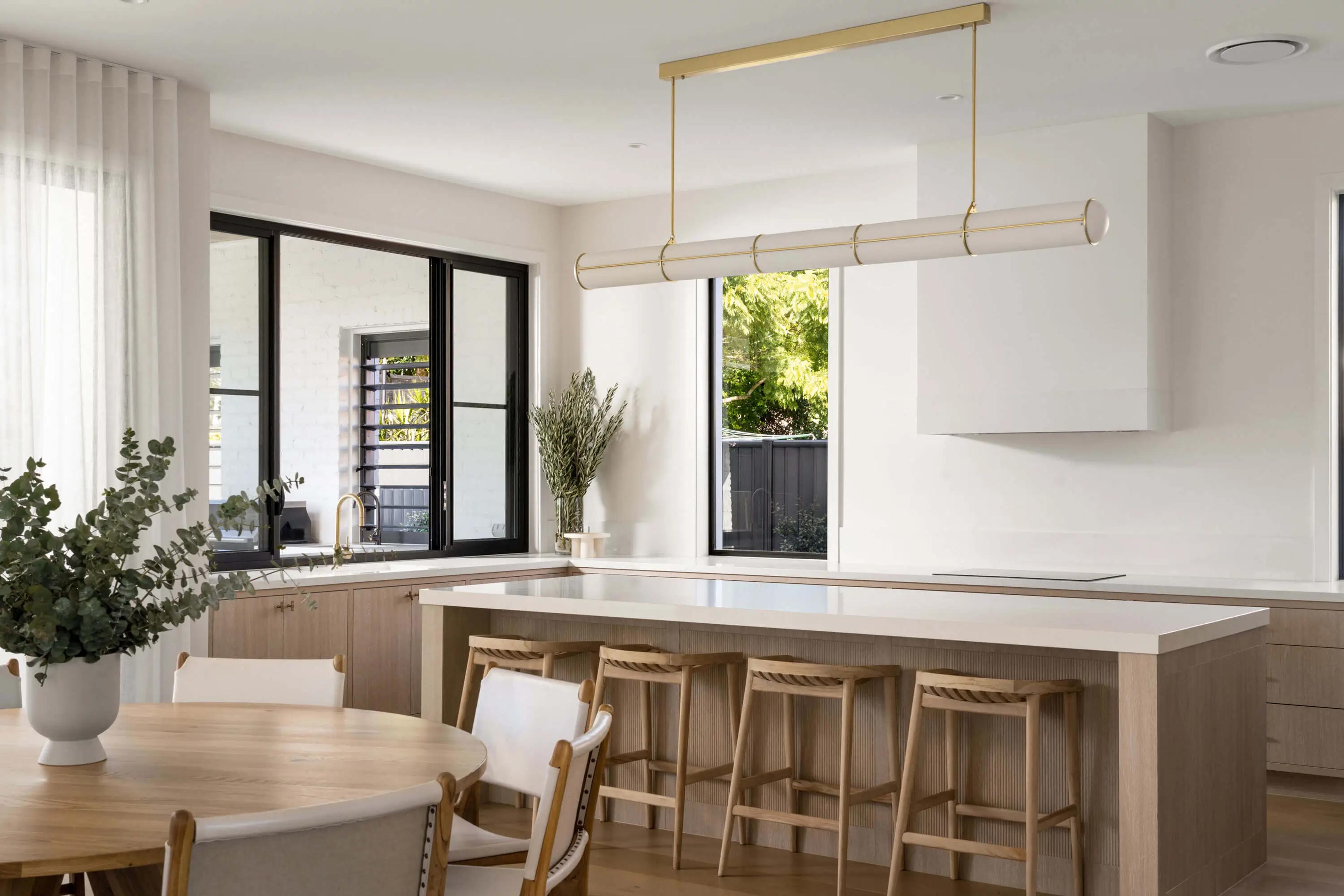 Kitchen island with bar stools and brass pendant light