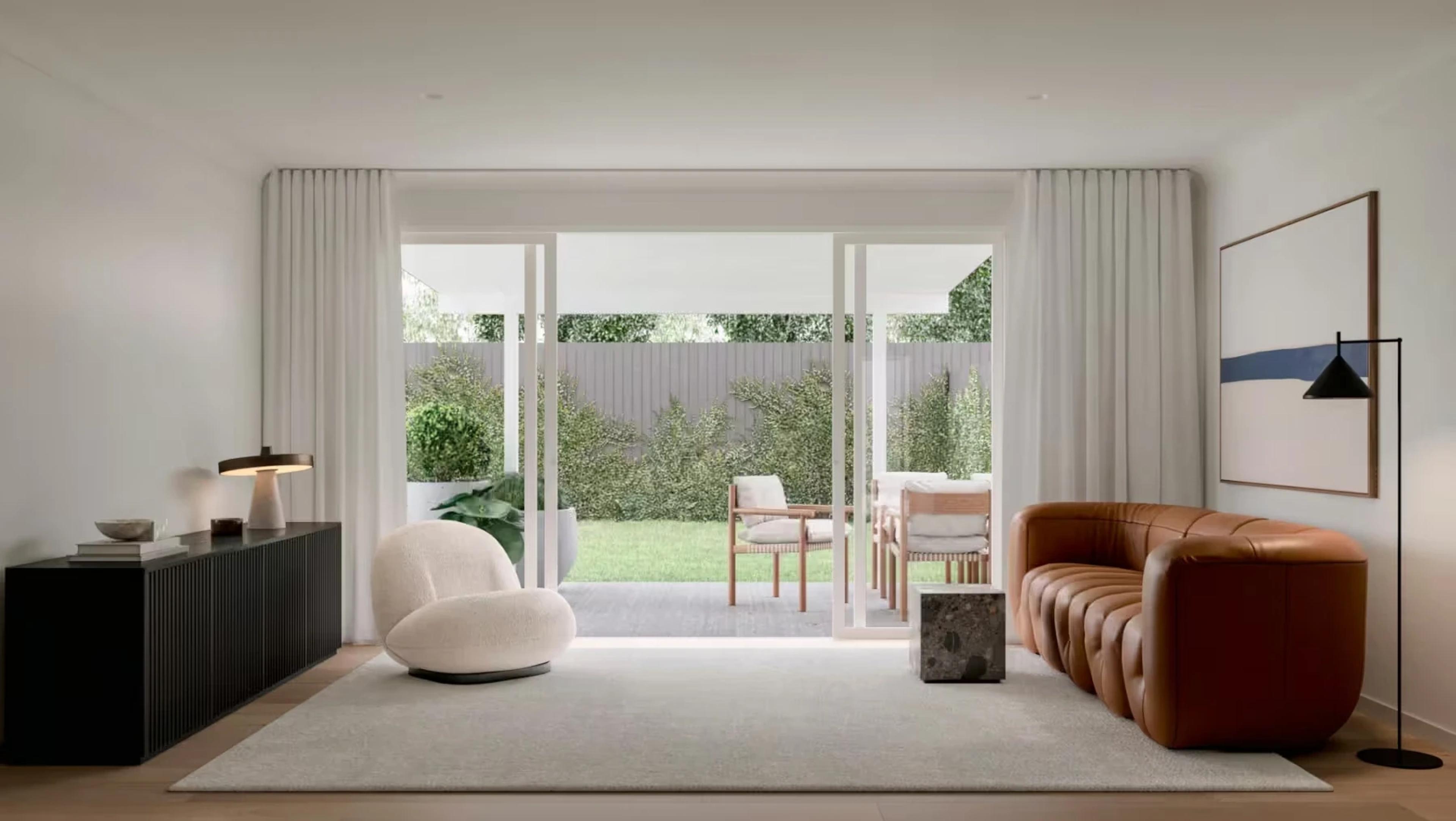 Living room with tan leather sofa and garden outlook