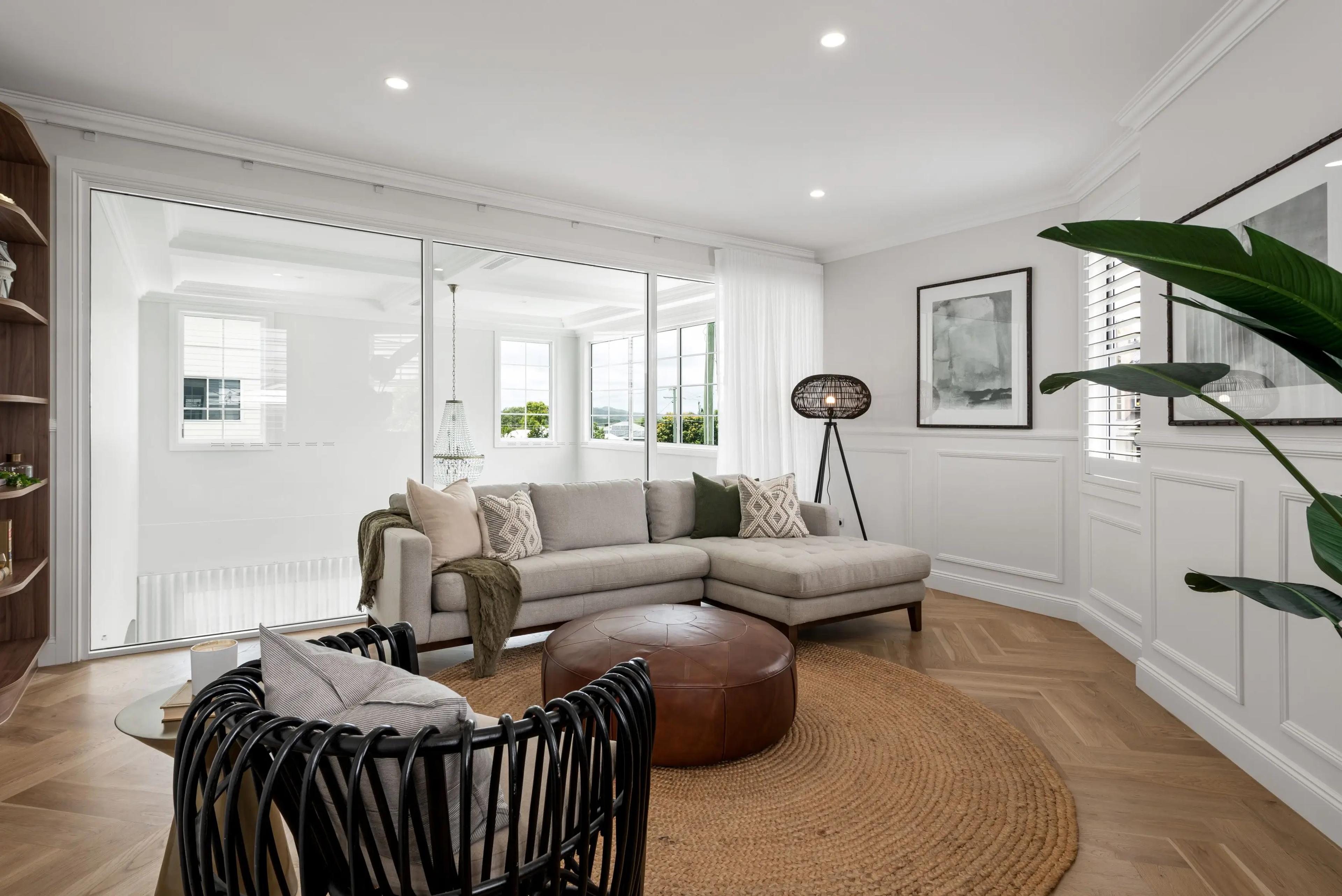 Living room with grey sofa, leather ottoman and garden views