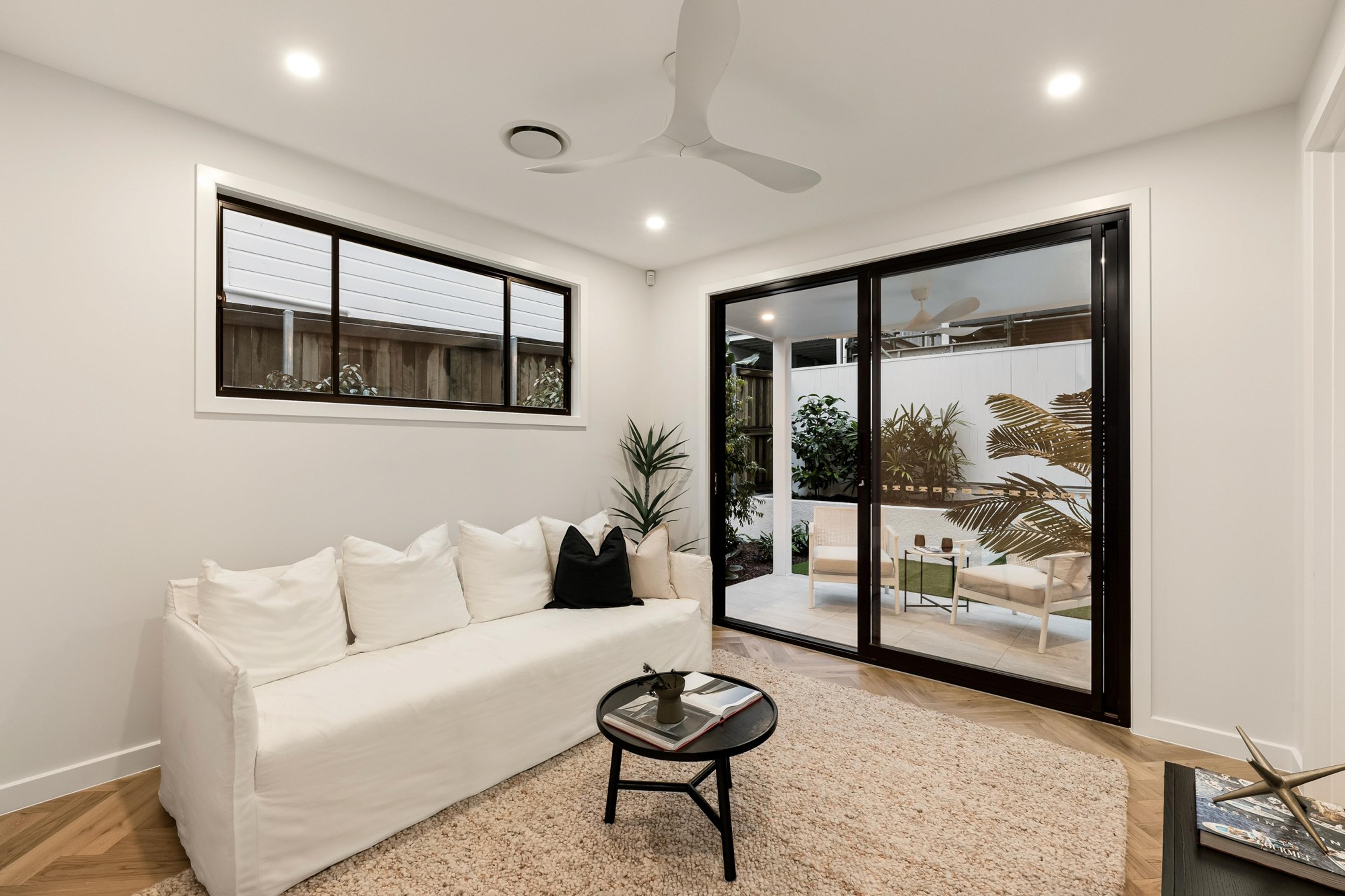 Sitting room with white sofa and glass doors to courtyard