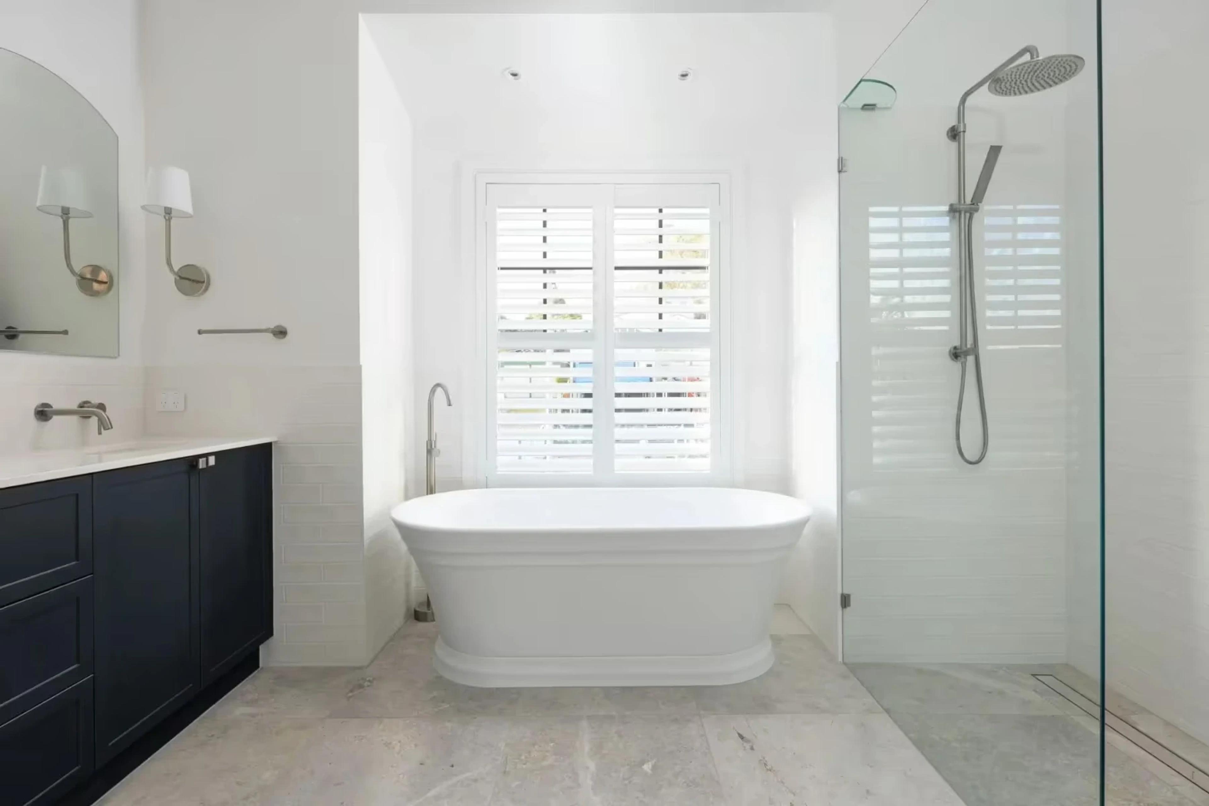 Ensuite with freestanding bath, navy vanity and glass shower
