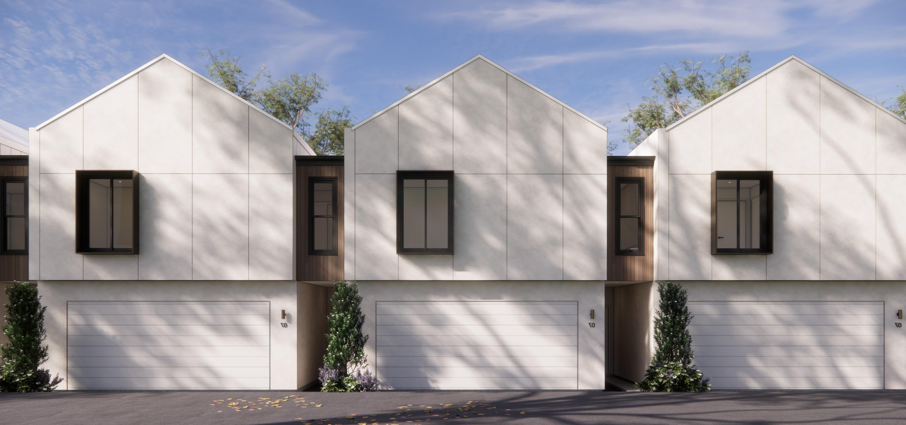 Gable roofed townhouses with white cladding and garages