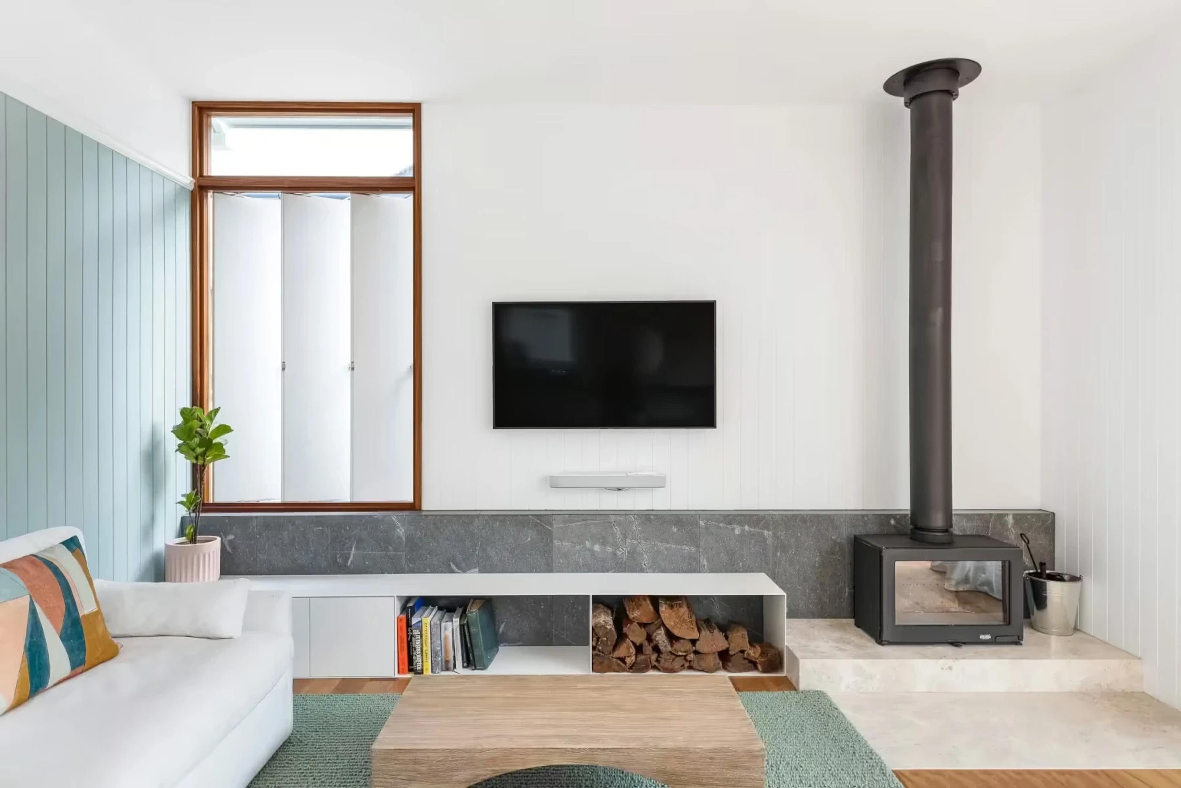 Living room with wood fire heater and stone hearth