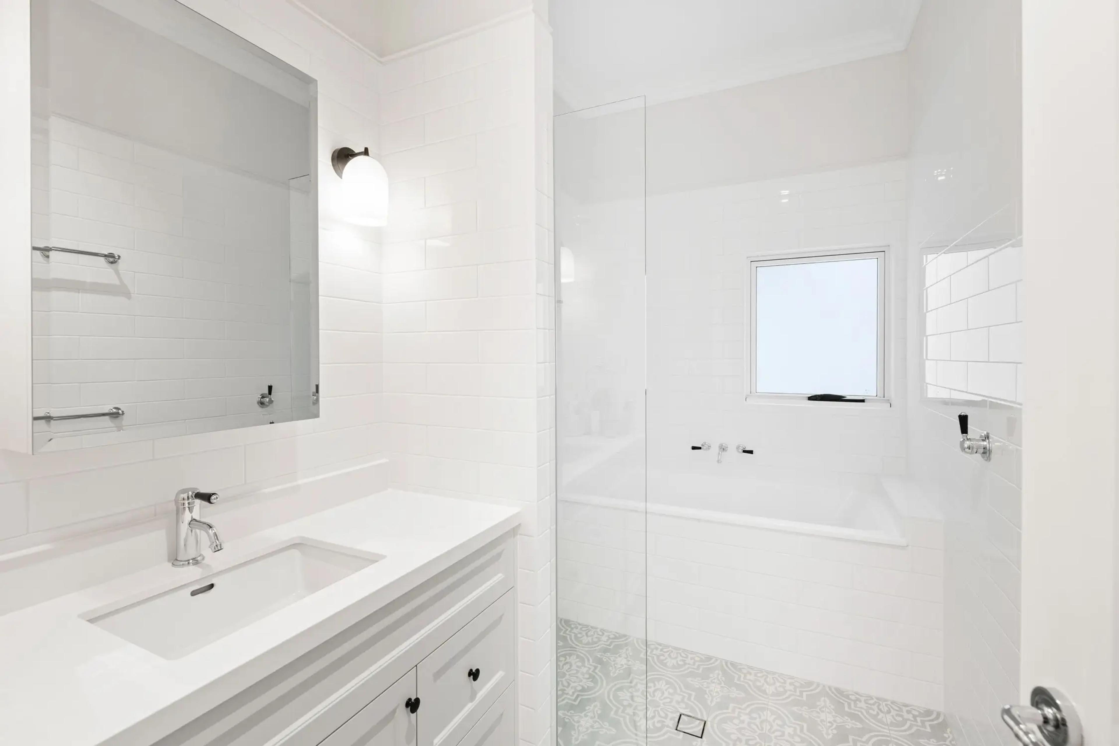 White bathroom with bath, shower and vanity