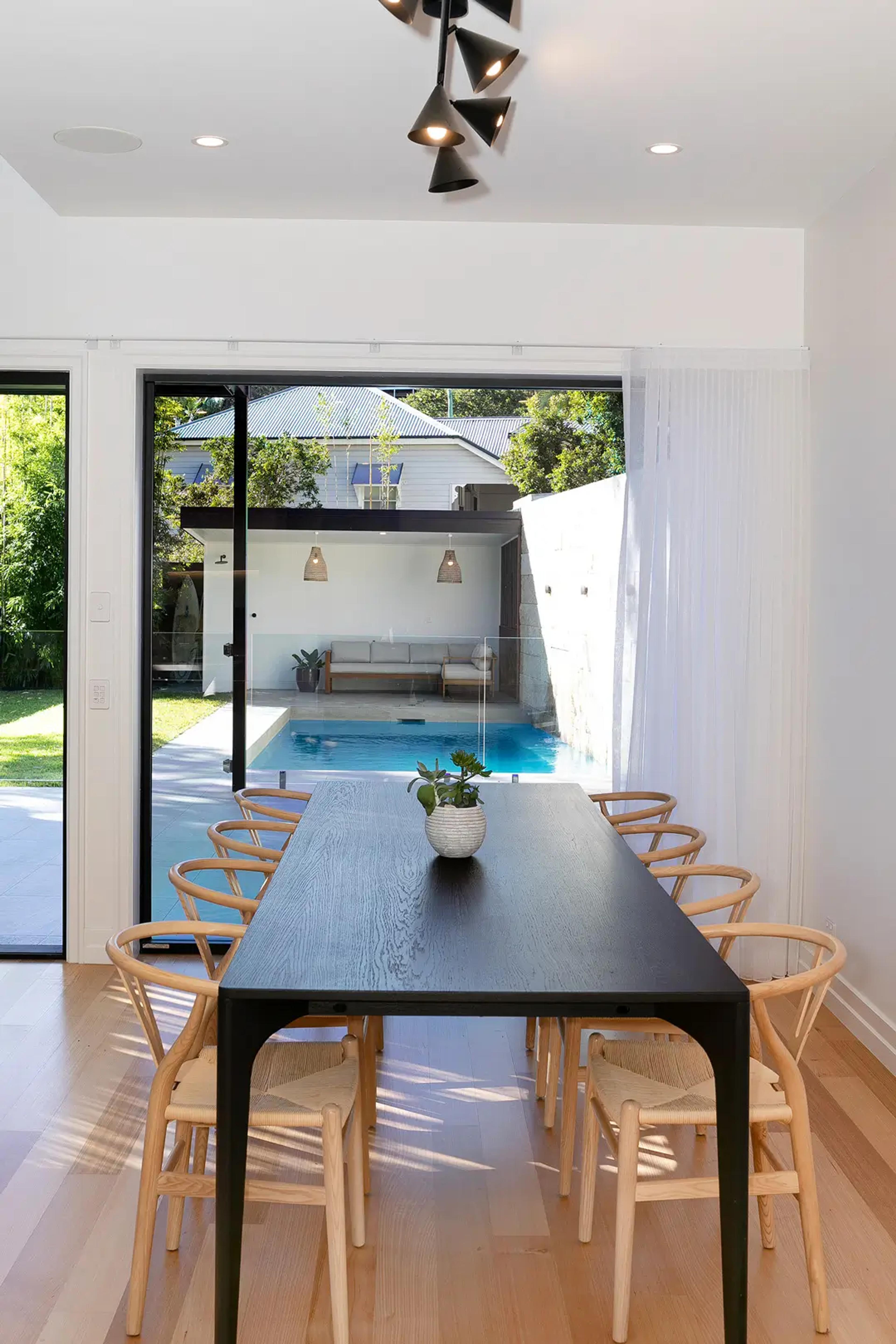 Dining table with view through sliding doors to pool and cabana