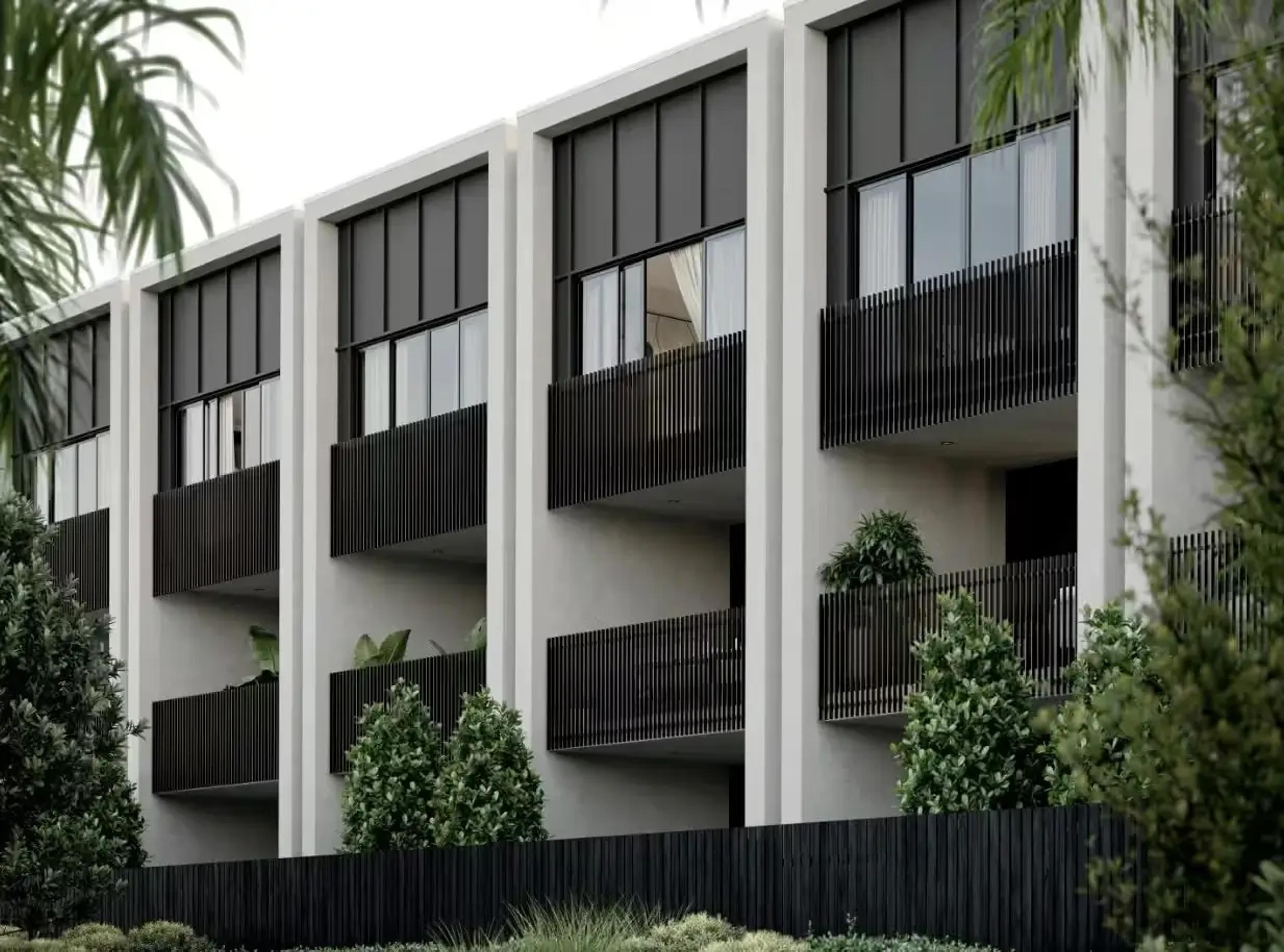 Townhouse facade with dark screened balconies and rendered columns