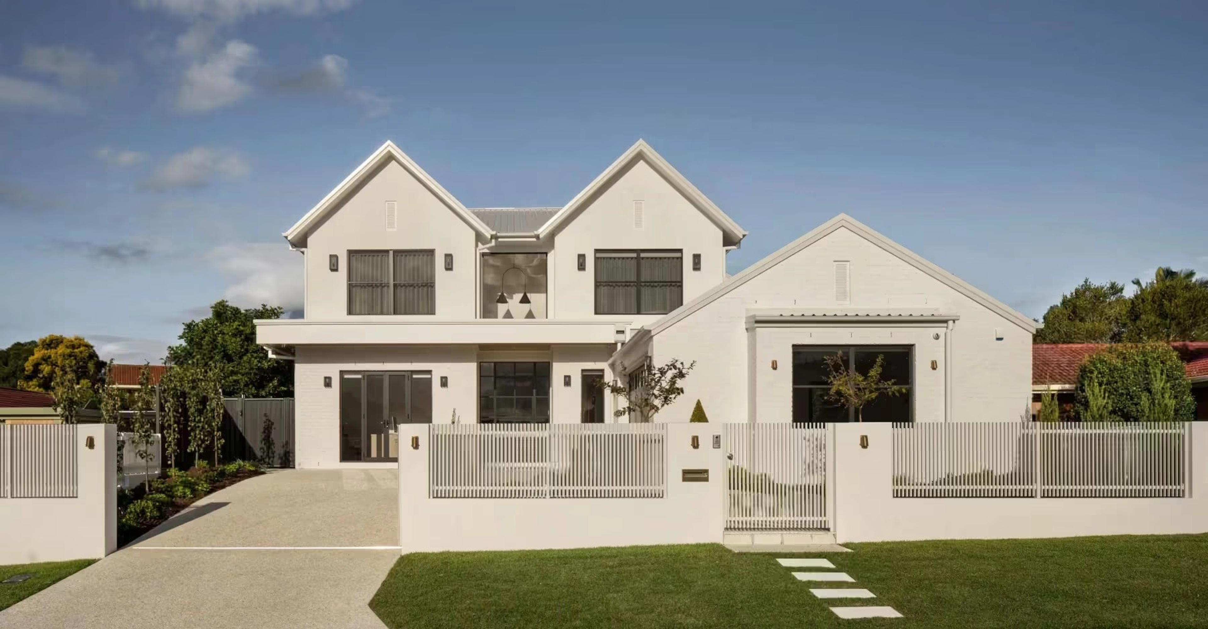 Modern house facades demonstrating crisp architectural lines, white cladding, and contrasting dark window frames.