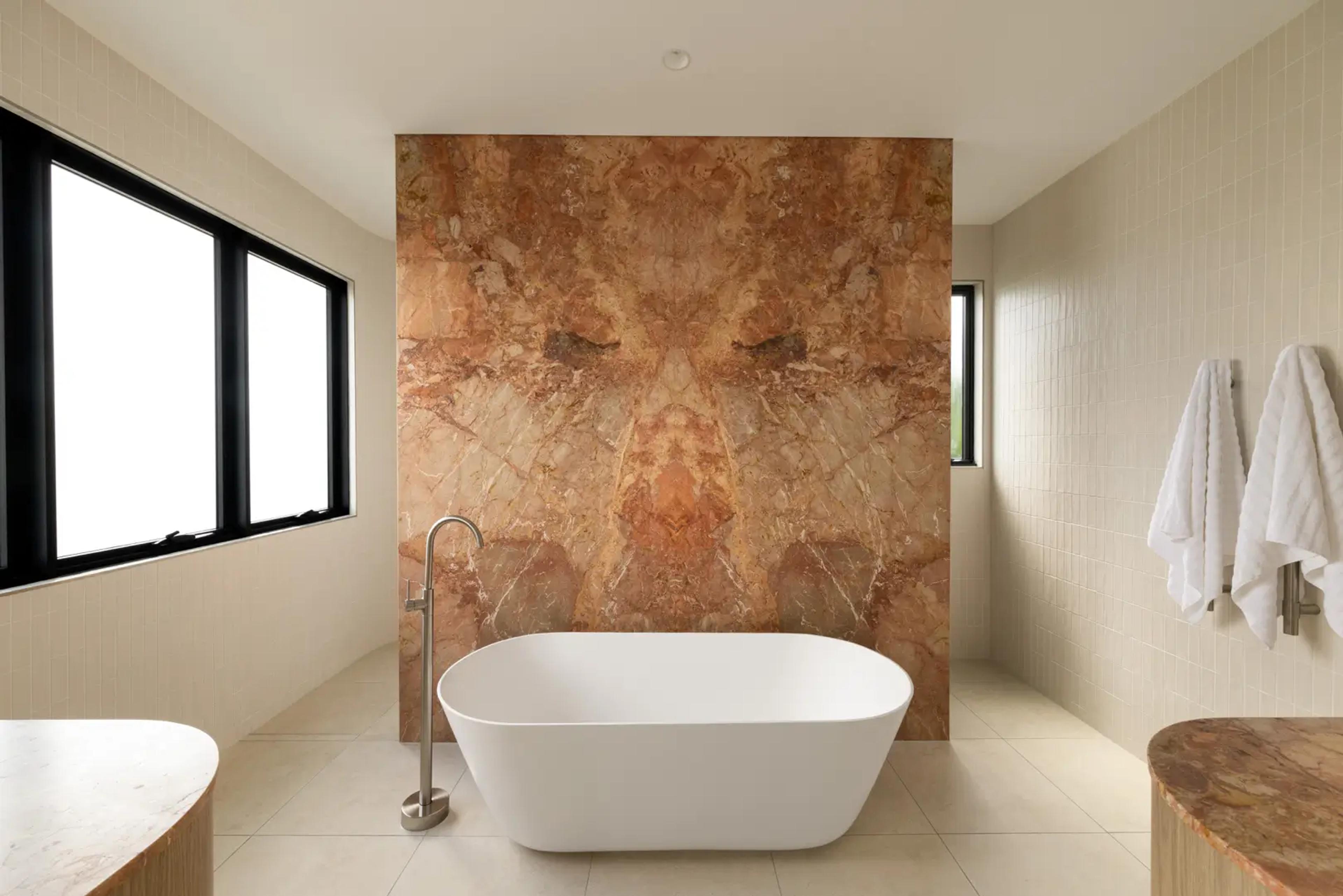 Bathroom with freestanding bath and marble feature wall