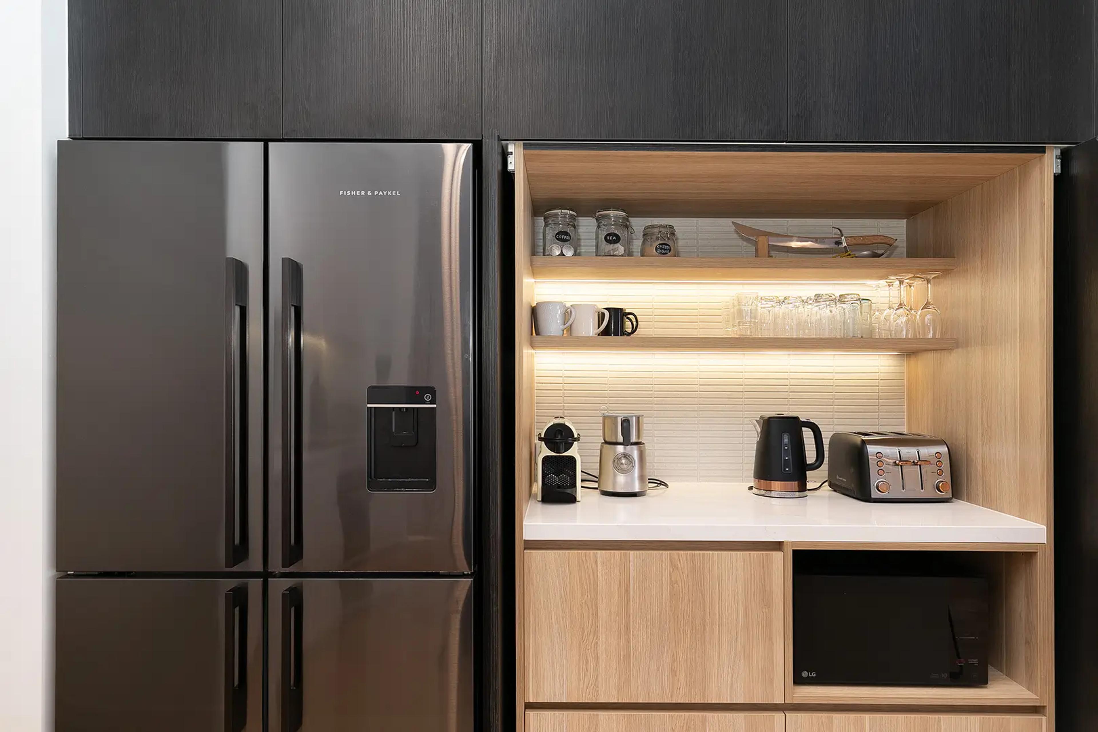 Butler's pantry with black fridge, timber shelving and coffee station